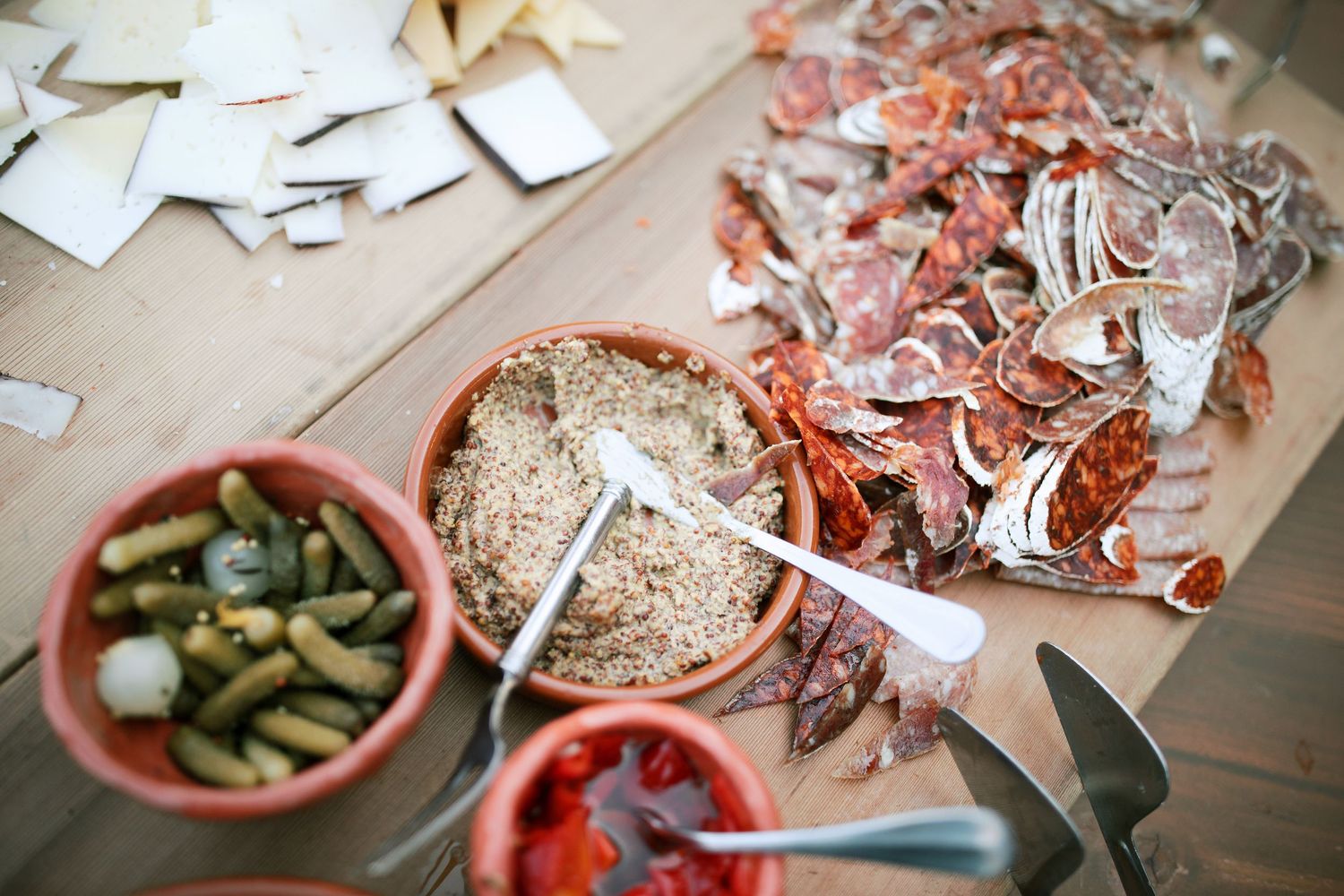 Aerial view of a messy table with seafood shells, pickles, and scattered papers during a casual dining experience.
