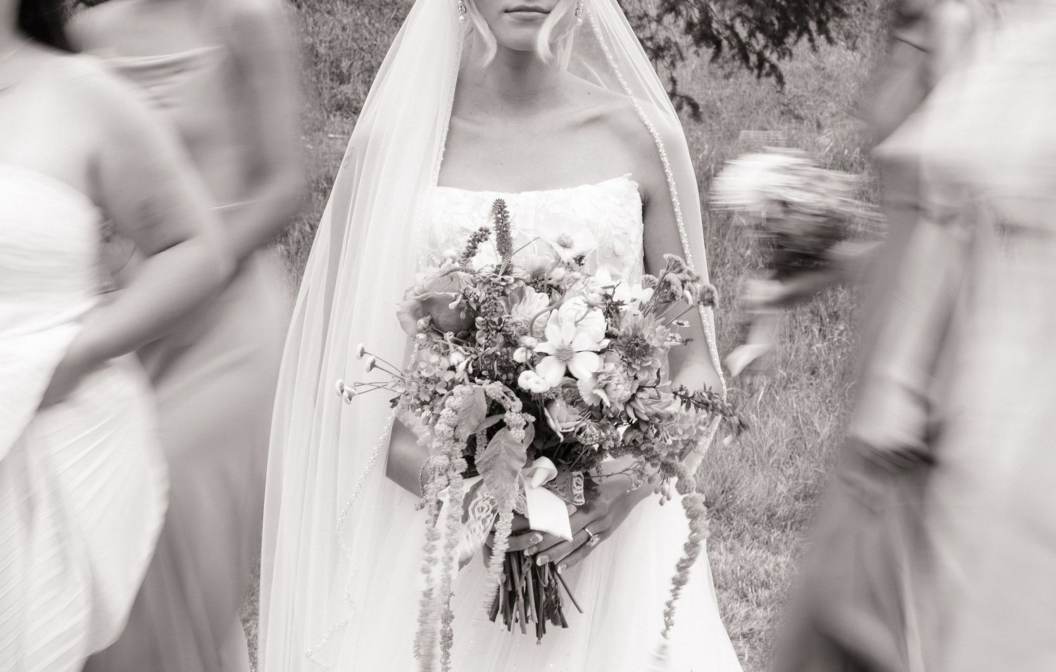 Black and white photo of bride and her bridesmaids with elegant wedding floral arrangements - Adrianna Elizabeth Photography.
