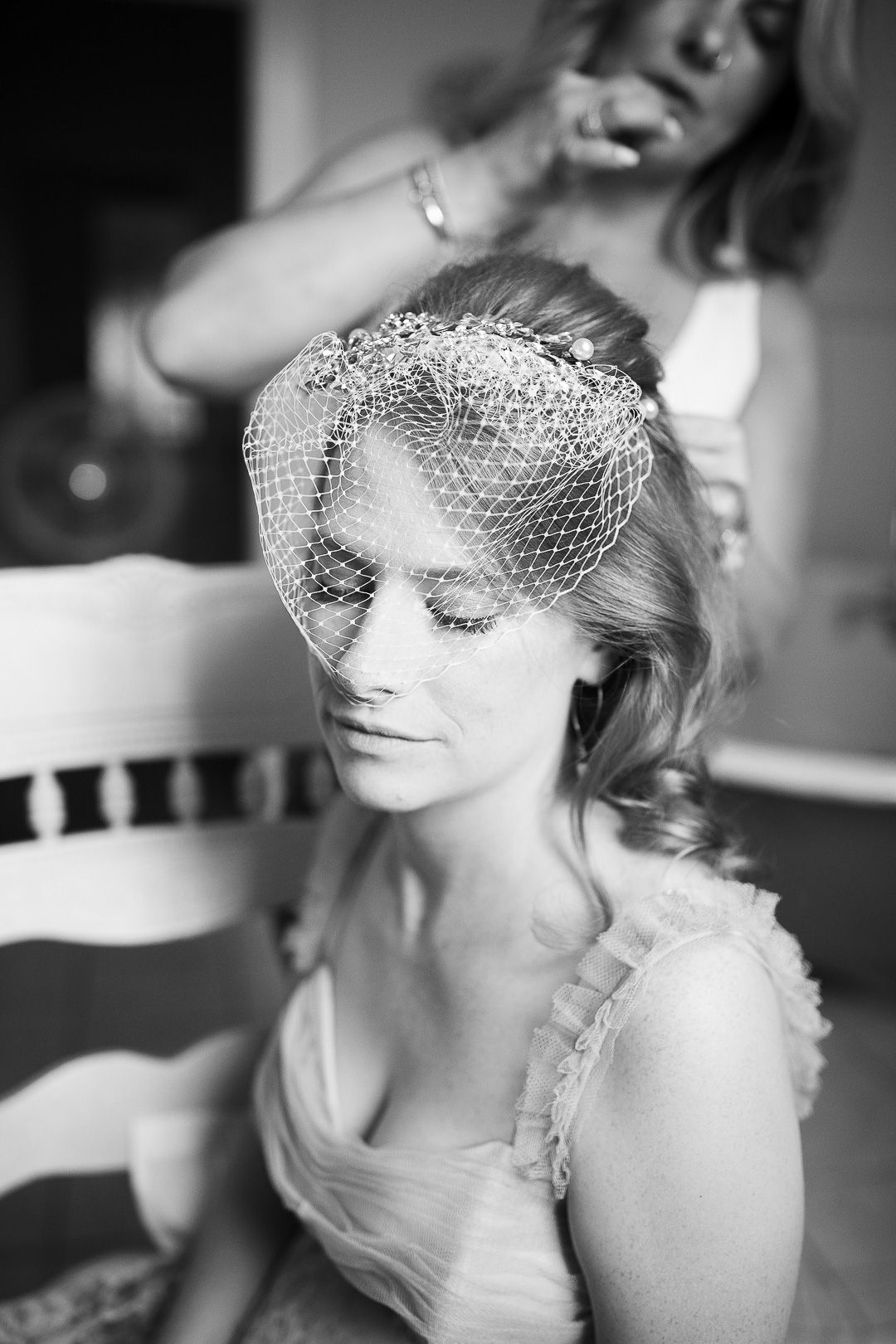 A series of black and white bridal portraits showing an elegant bride wearing a birdcage veil and vintage-inspired styling.