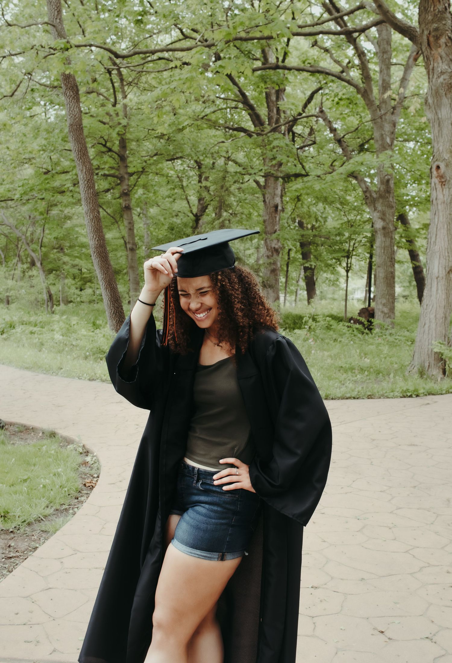 High school senior is bowing with her cap and gown for graduation