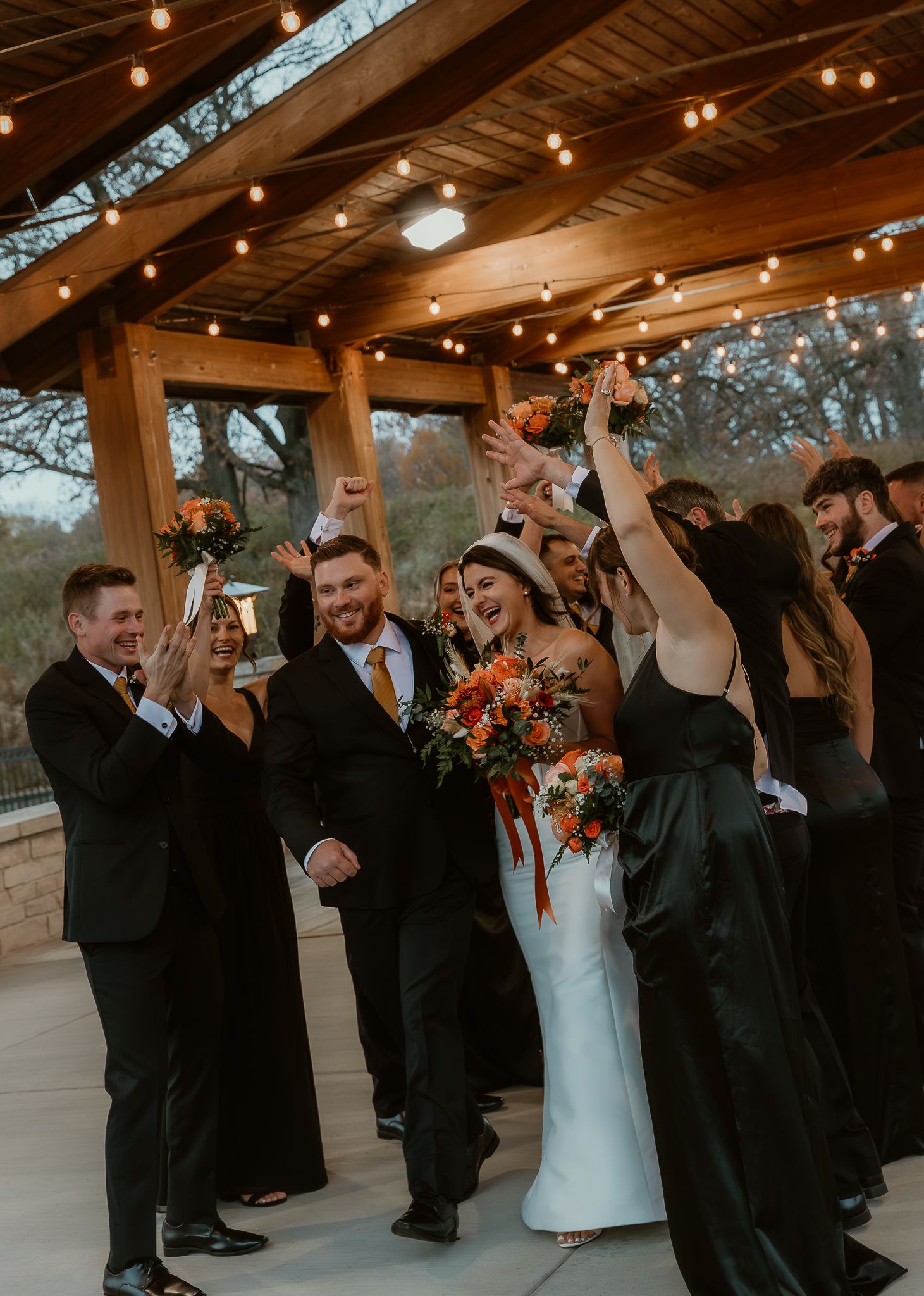 Bride and Groom walk through their wedding party cheering for them during wedding party portraits