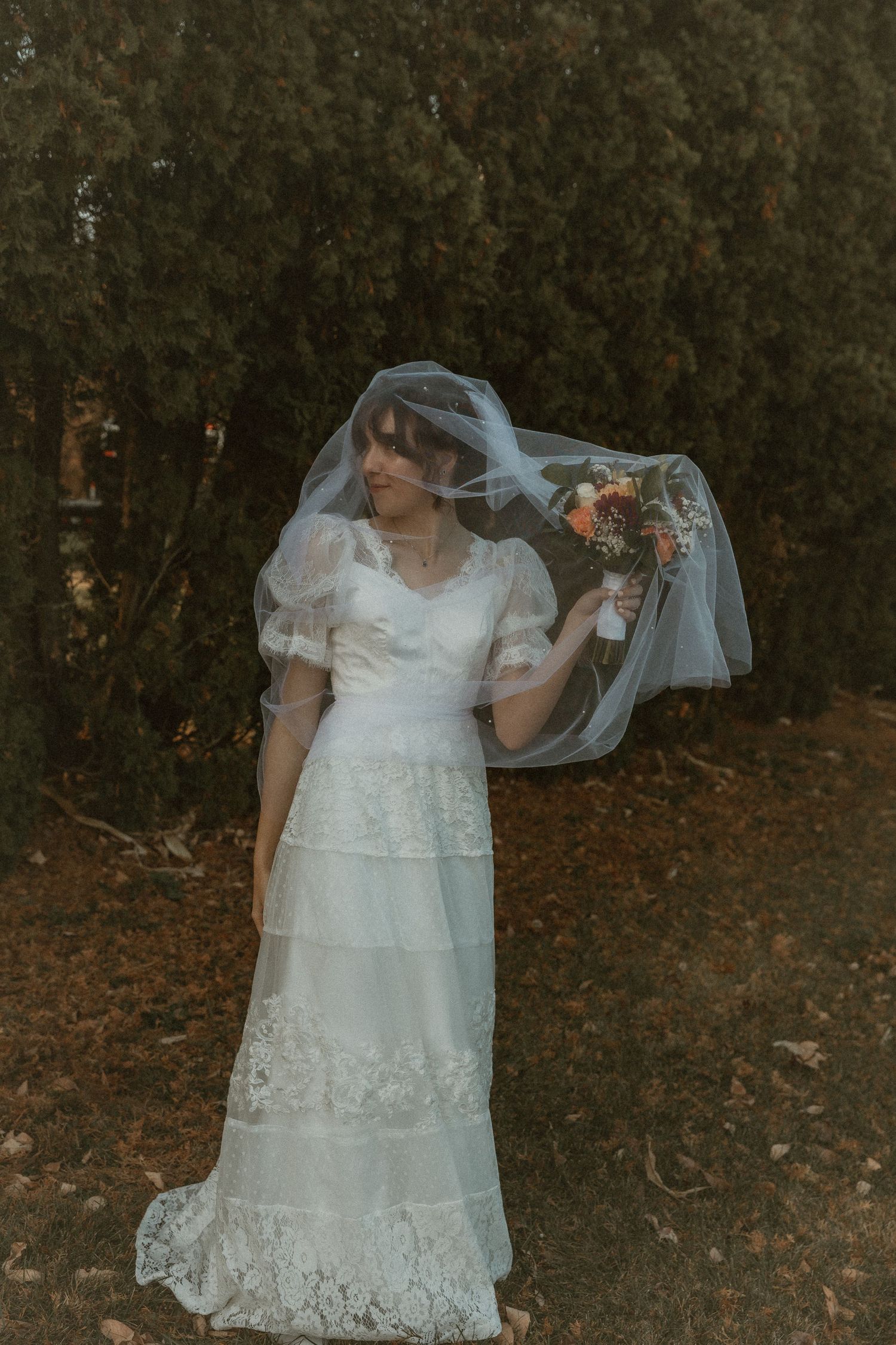 Bride and her bouquet elegantly draped under a flowing veil, capturing a romantic and serene wedding moment ; Idaho Elopement Photographer