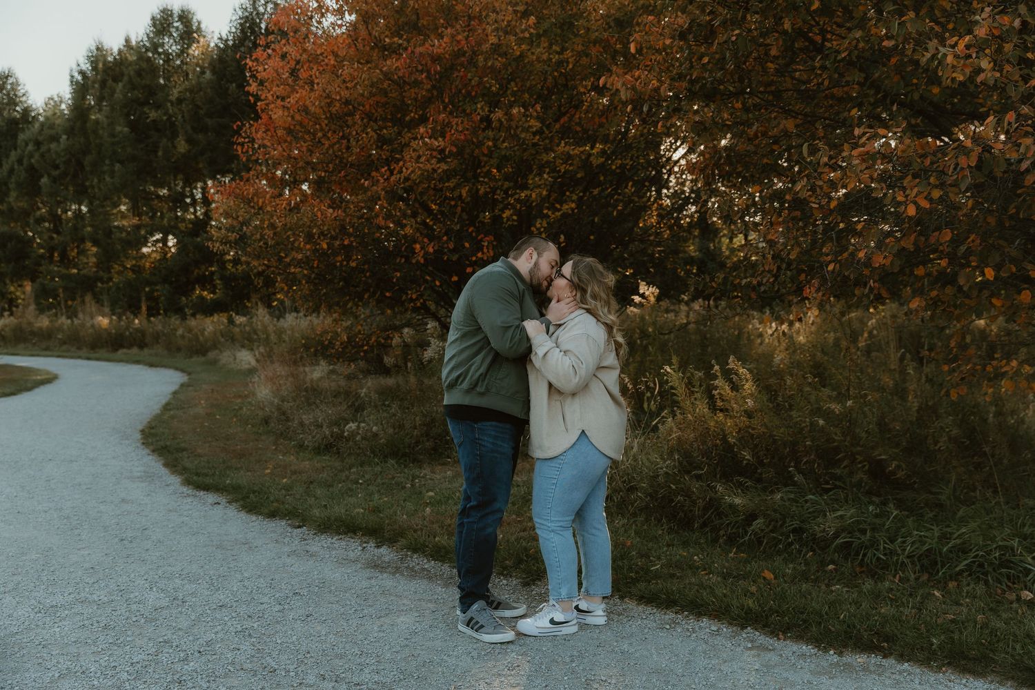 Couple shares a kiss in a nature setting for their engagement photos with central illinois wedding photographer