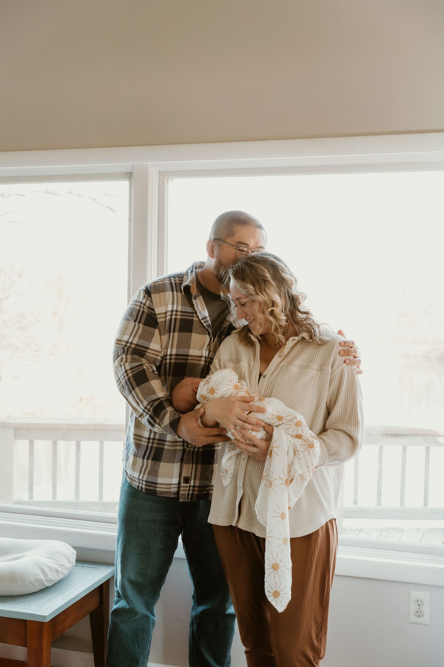 Mom and dad holding newborn baby for a lifestyle newborn session with Central Illinois Photographer