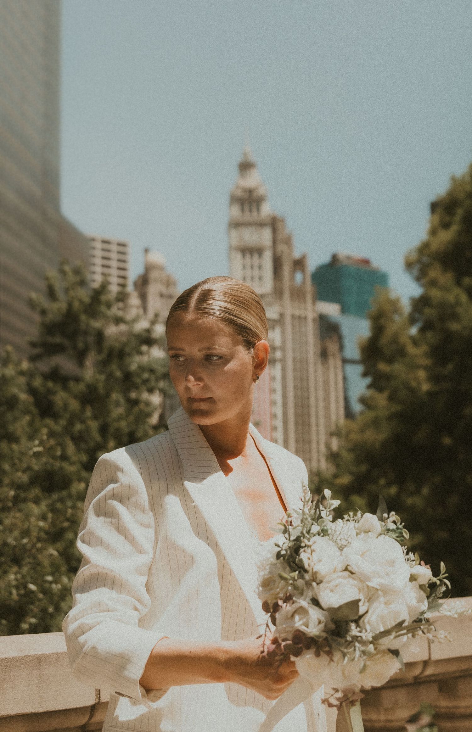 Modern wedding portrait in downtown Chicago, IL featuring a bride holding a white bouquet, captured by a local bloomington photographer