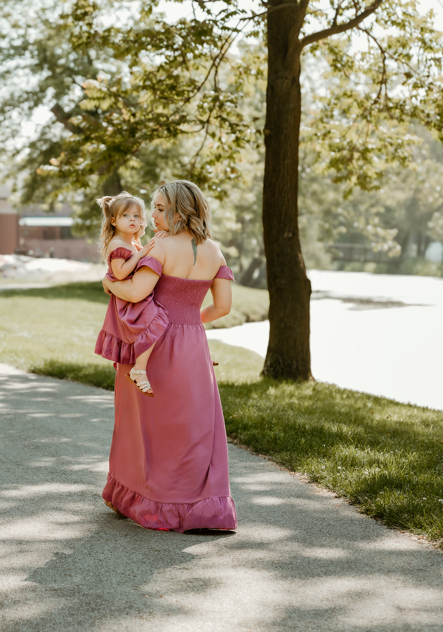 Mom holding her daughter while taking a stroll along the river during a lovely day