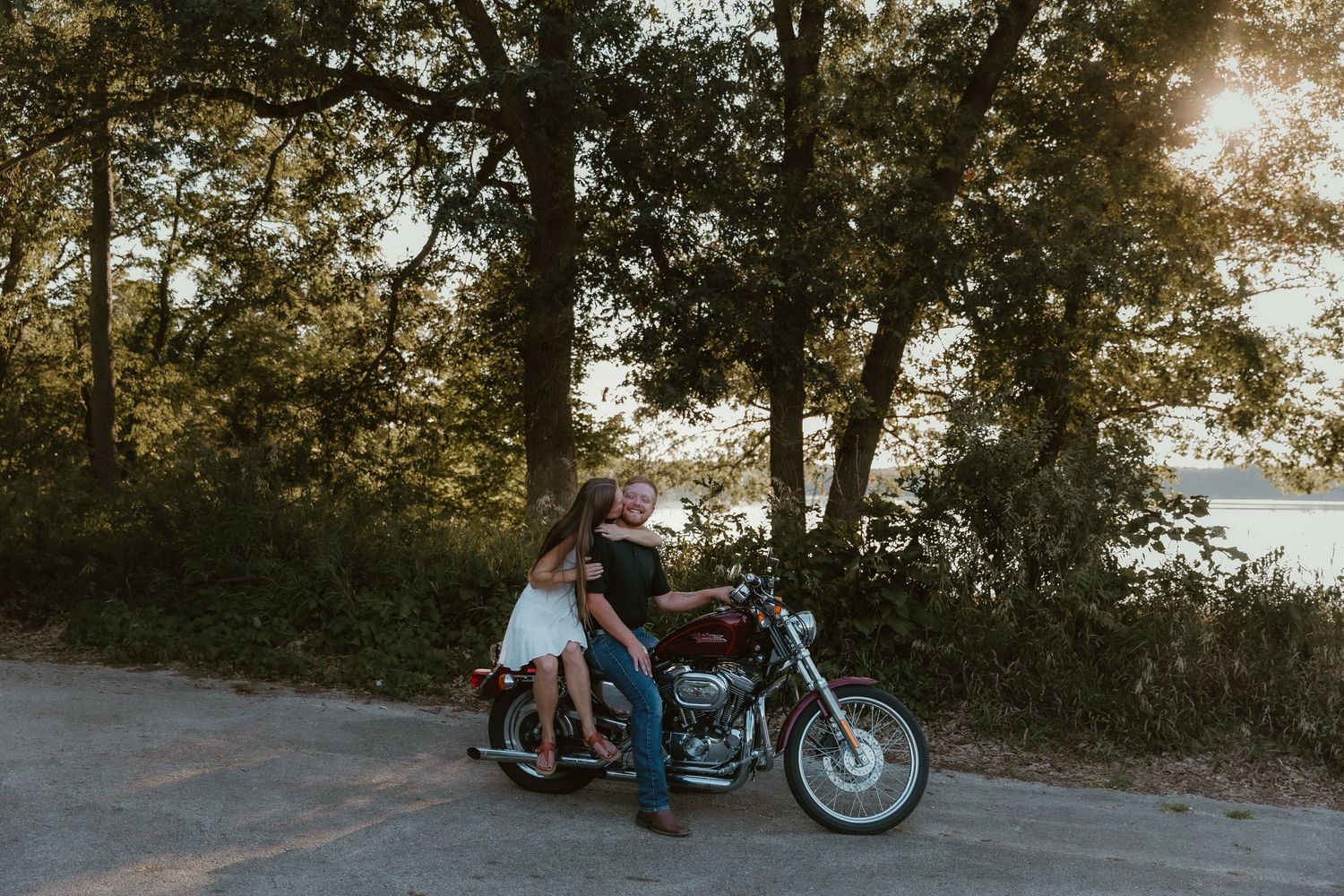 Couple sits on their motorcycle and shares a romantic cuddle moment while central illinois wedding photographer captures their love