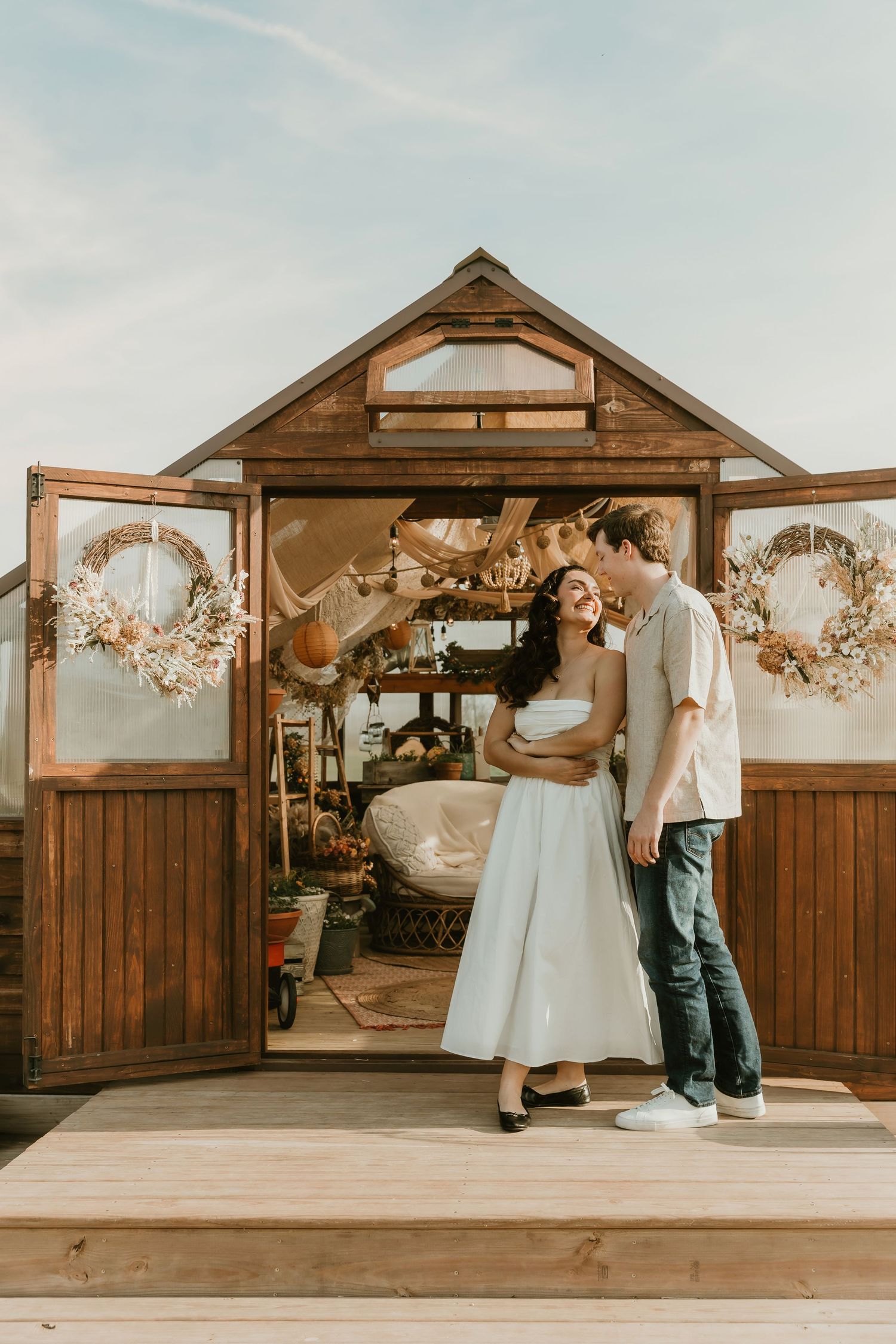 Couple share candid moment in a greenhouse setting during an engagement photo session with central illinois photographer