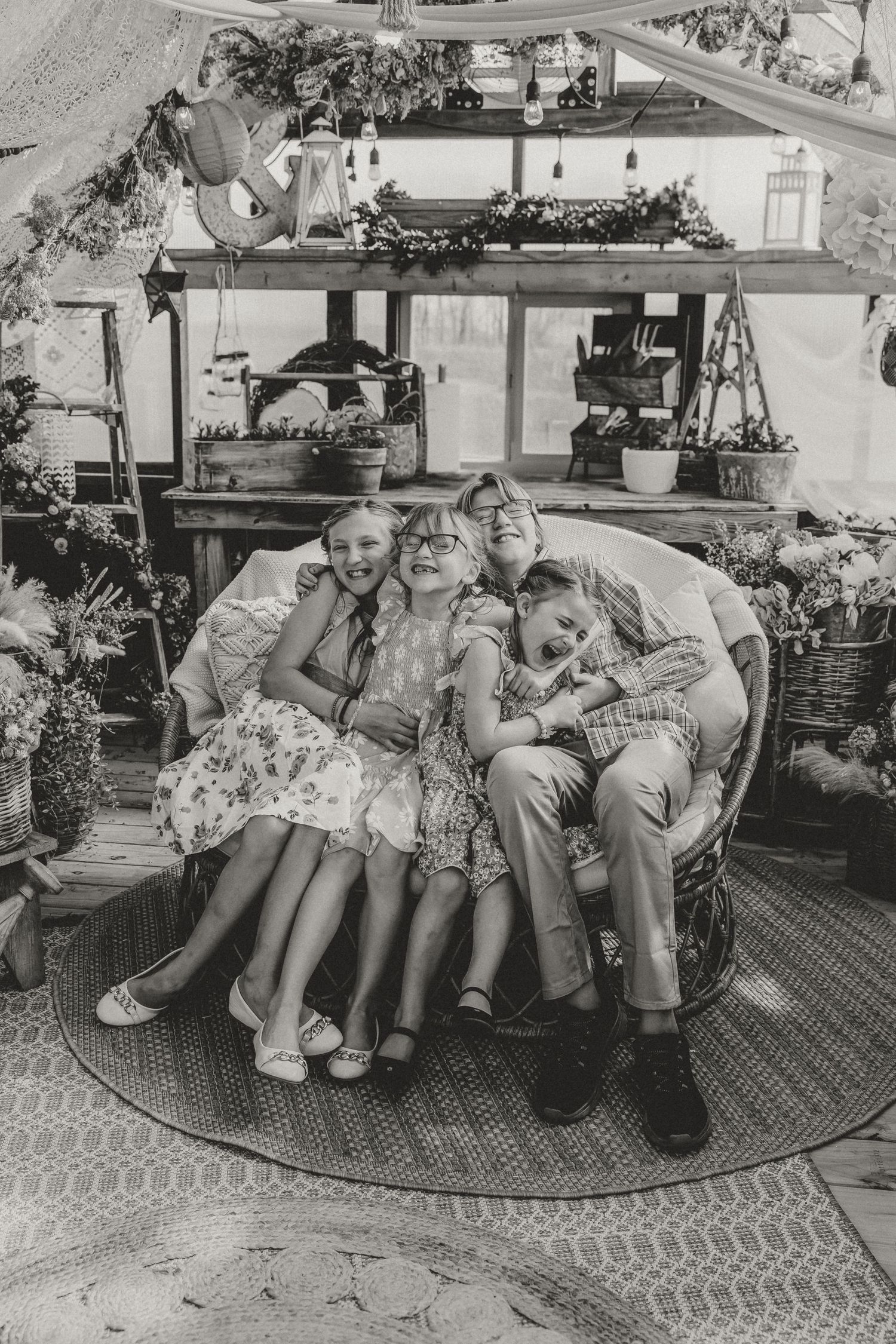 Playful sibling photo in a greenhouse during a family photo session with central illinois family photographer