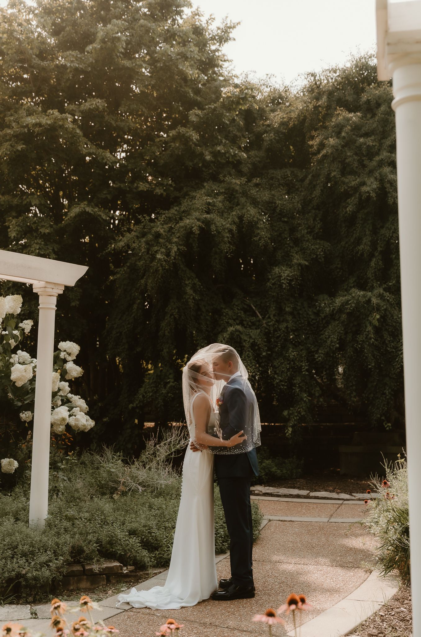 Bride and Groom cuddle into each other during golden hour wedding portraits with central illinois wedding photographer