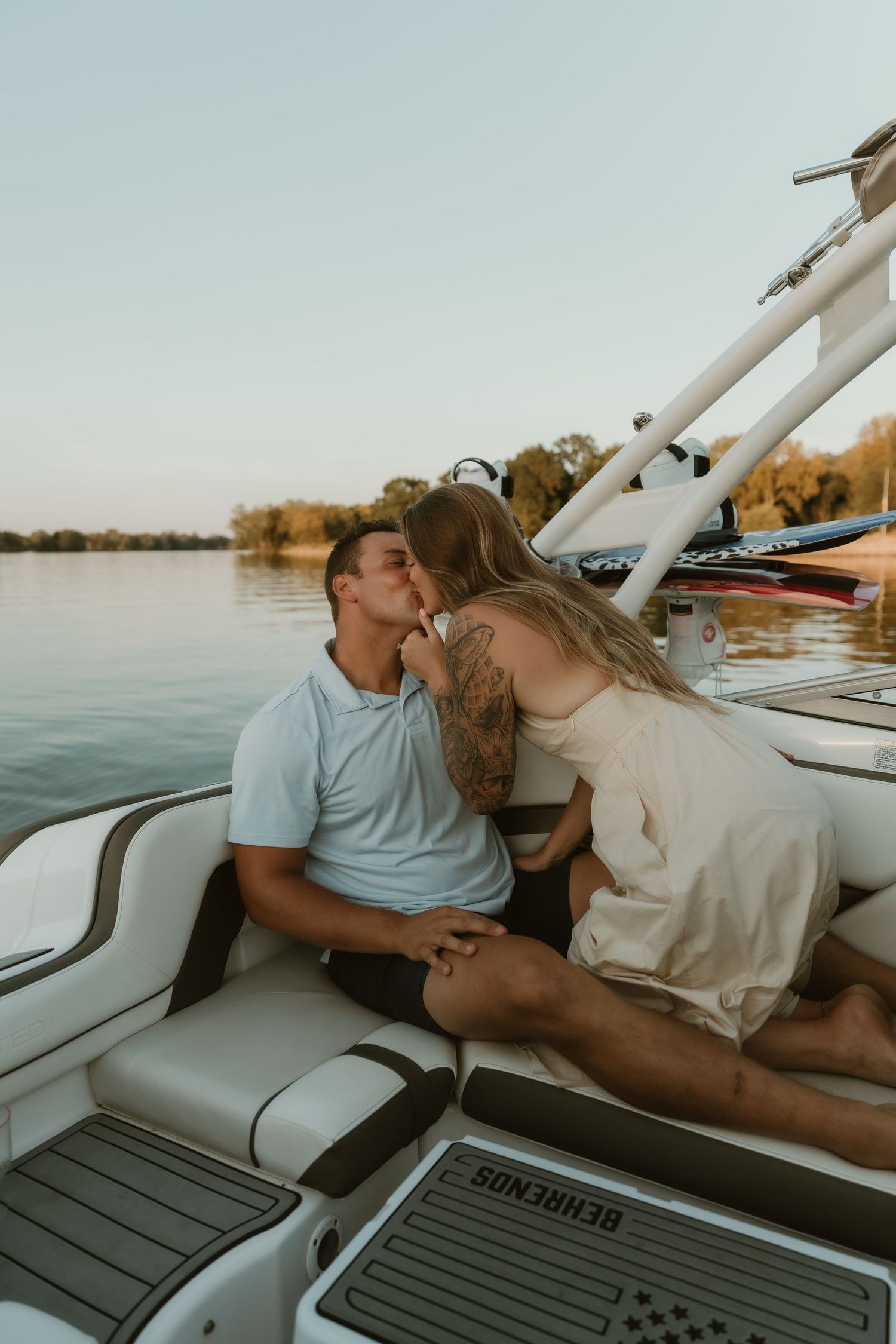 Romantic photo of a couple sharing a kiss on their boat in golden light. Intimate and emotional moment captured by illinois photographer