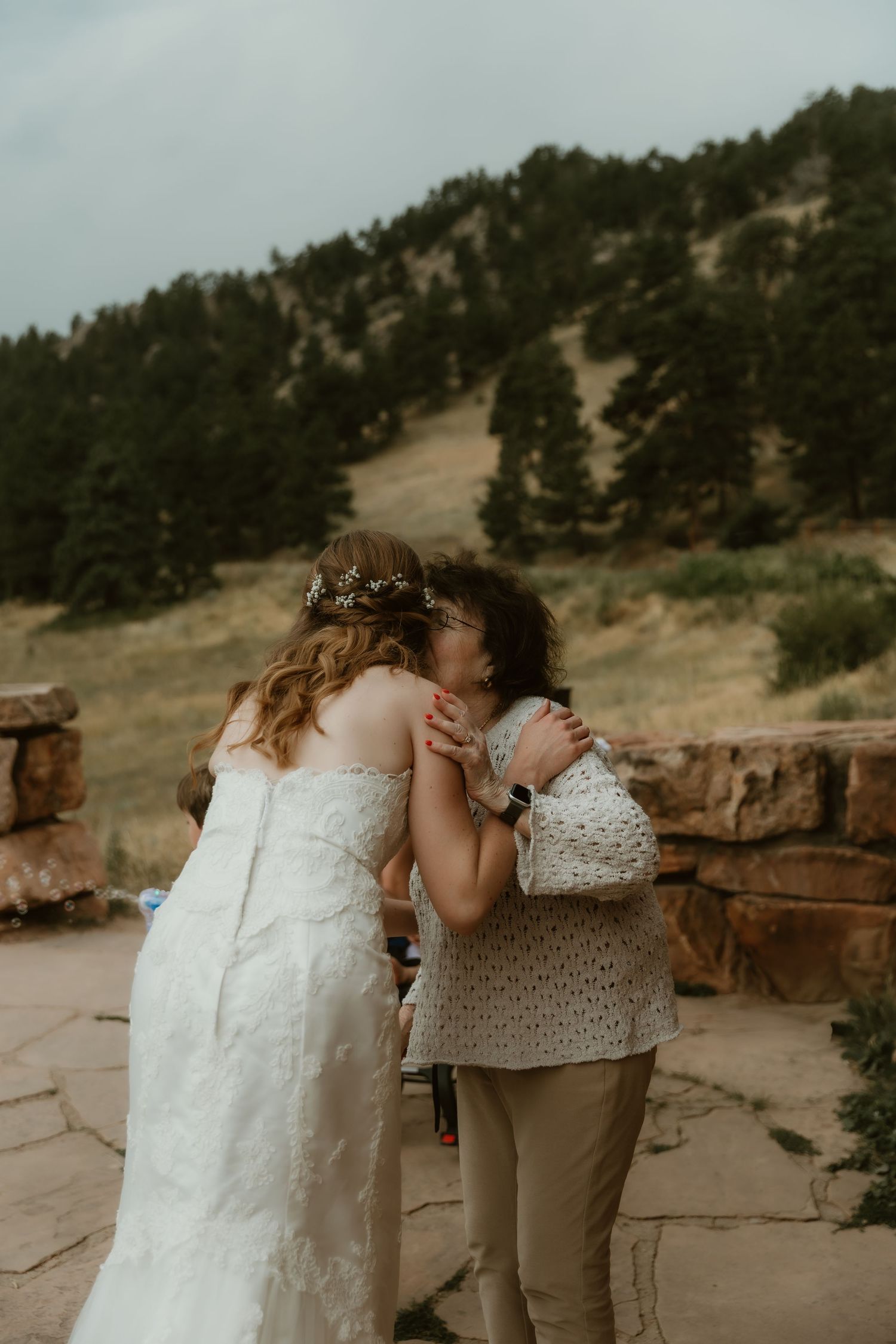 Grandma of the bride kisses her grandchild's cheek after her wedding ceremony during a sweet moment