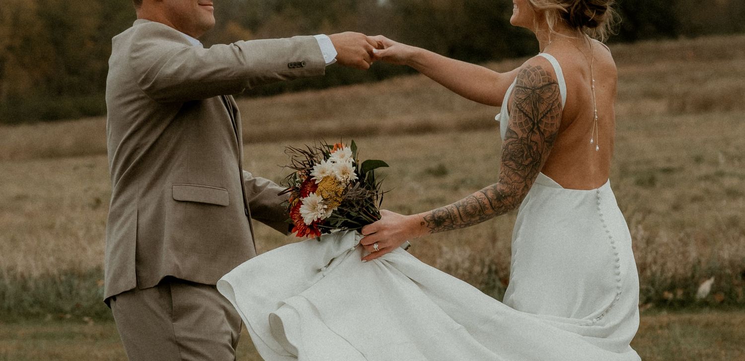 Groom spins bride during wedding portraits in an open field with illinois elopement photographer