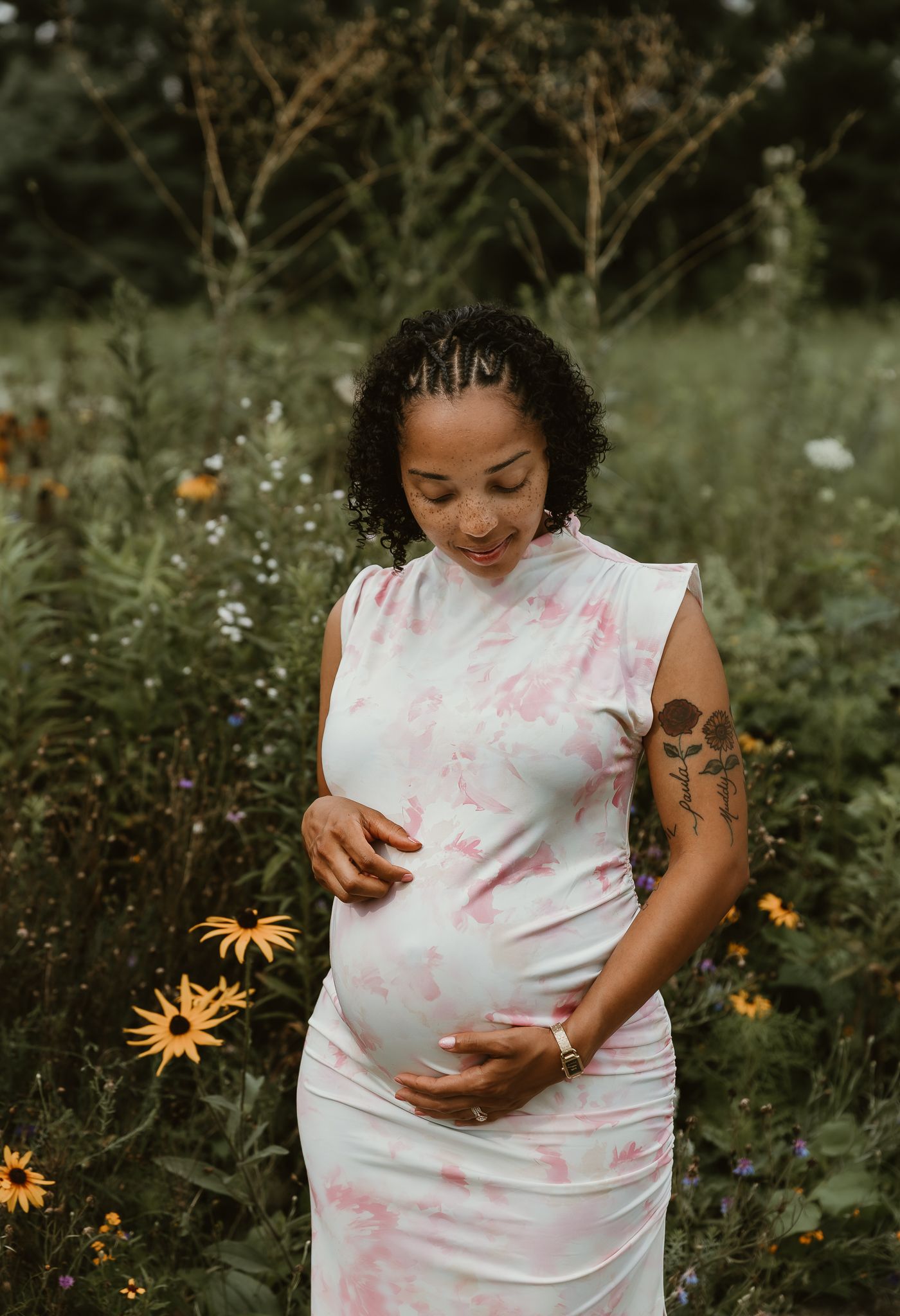 Mother holds and gazes at her belly during a maternity session in Normal, IL with central illinois maternity photographer