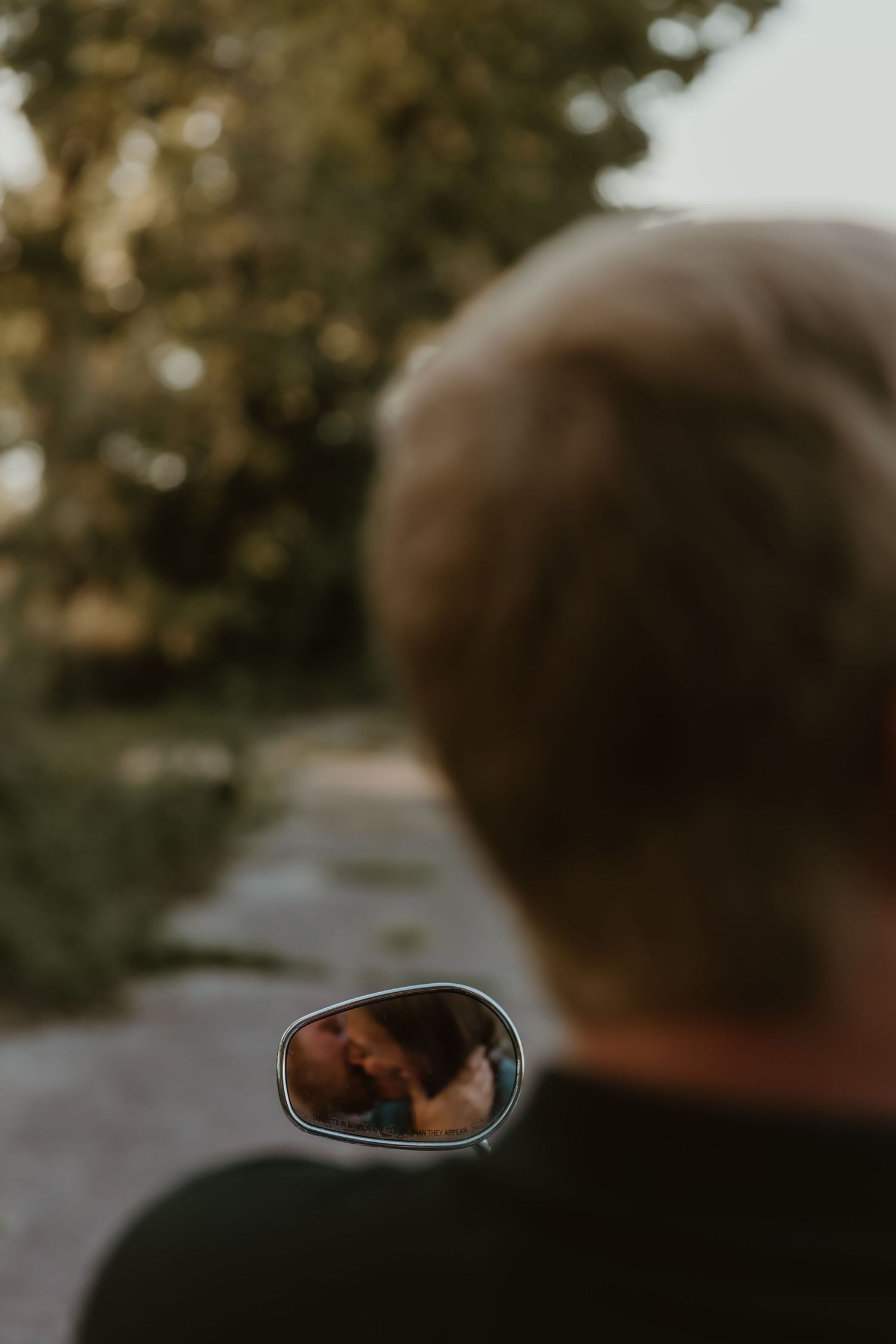 Couple shares an intimate kiss during their engagement session with a motorcycle