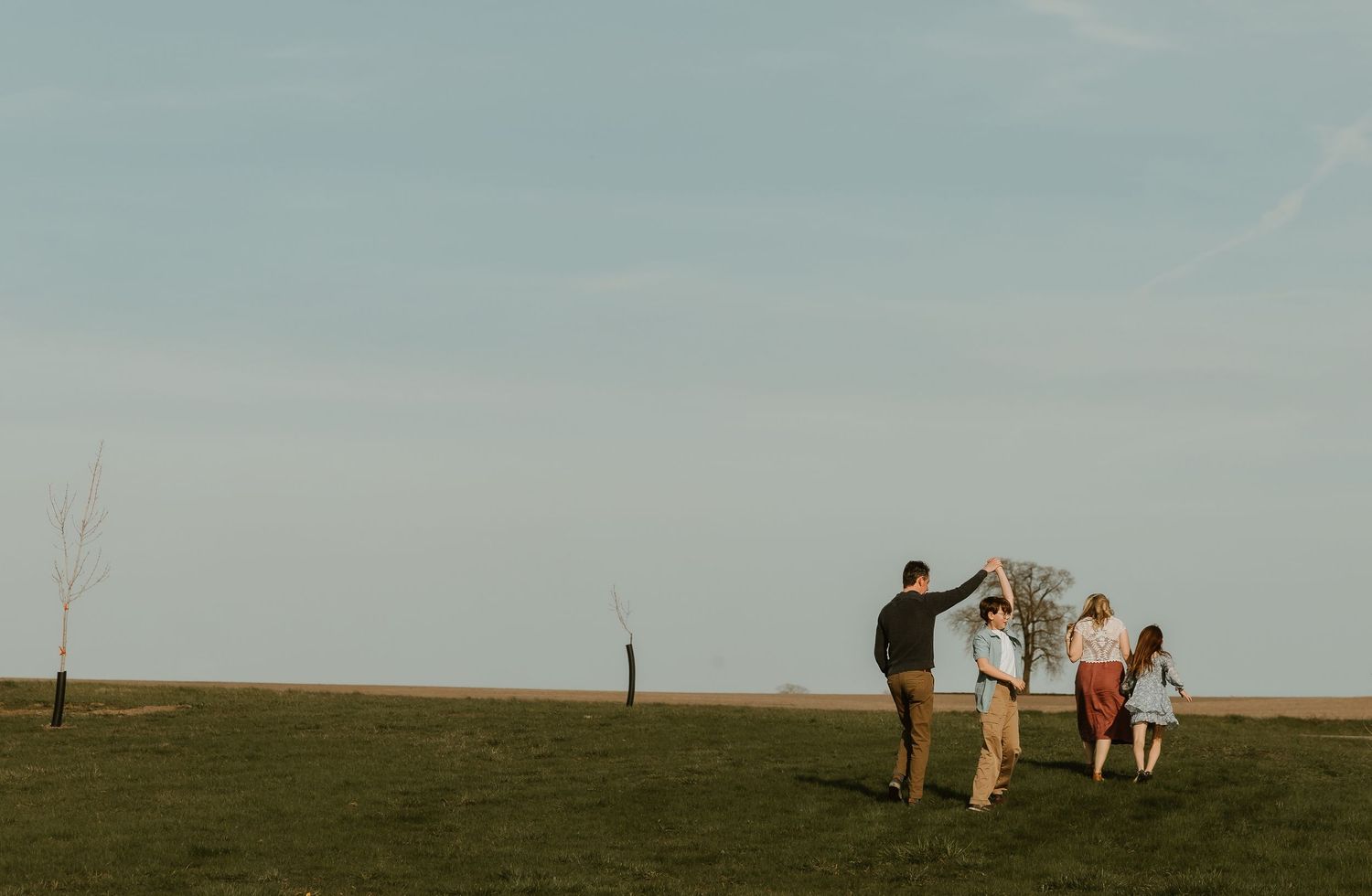 Sehl Photography Central IL photographer captures playful movement across sunlit grass—joyful bonds, natural beauty, and nostalgic calm