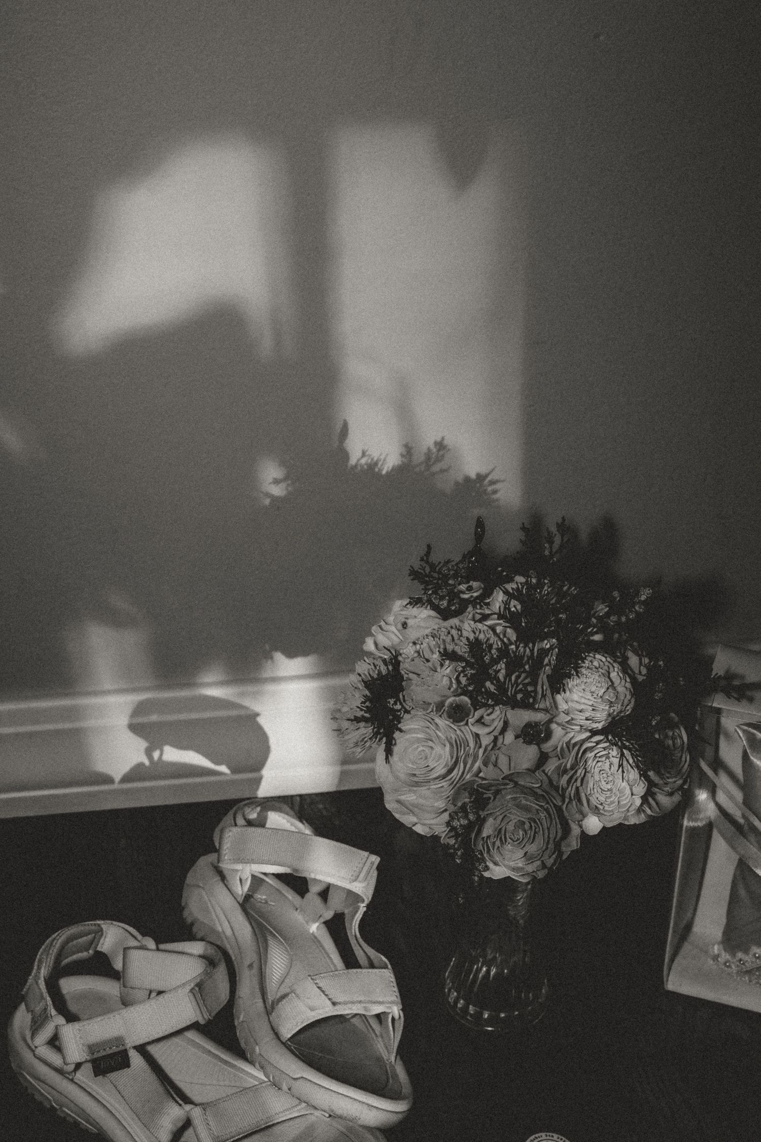 Silhouette of flowers casted on the wall during detail shots with central illinois wedding photographer