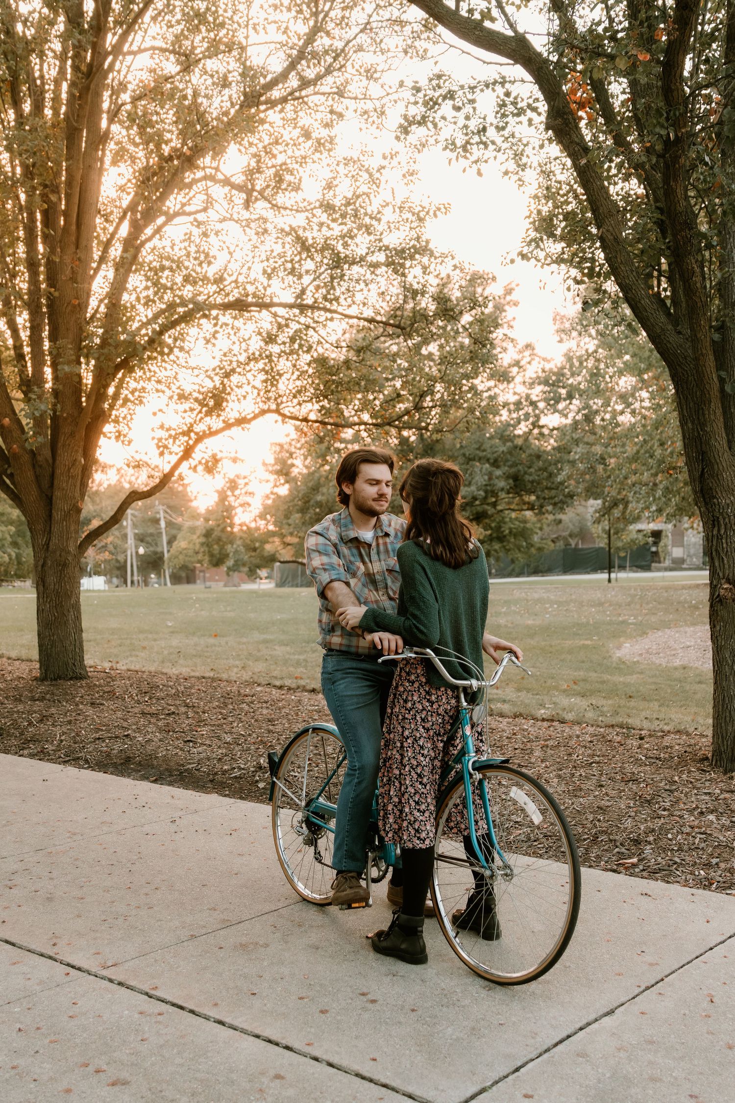 Couple chatting on a bike during sunset for their engagement photos