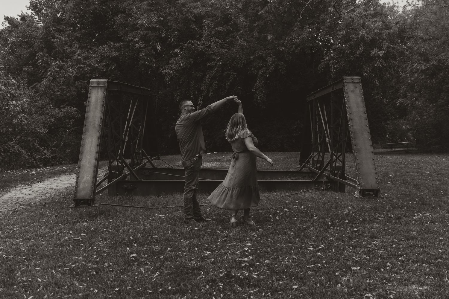 Couple dances joyfully in a serene natural setting during a family photo session
