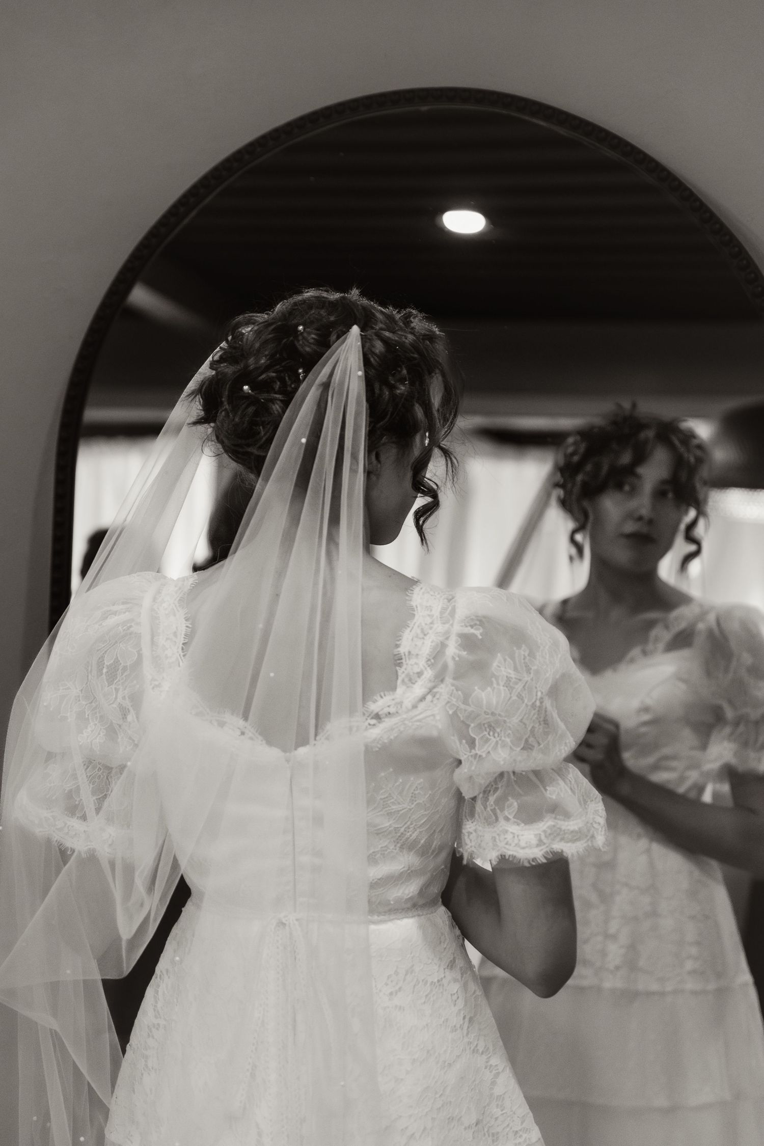 Close-up black and white shot of a bride getting ready, capturing the elegance and anticipation of her wedding day