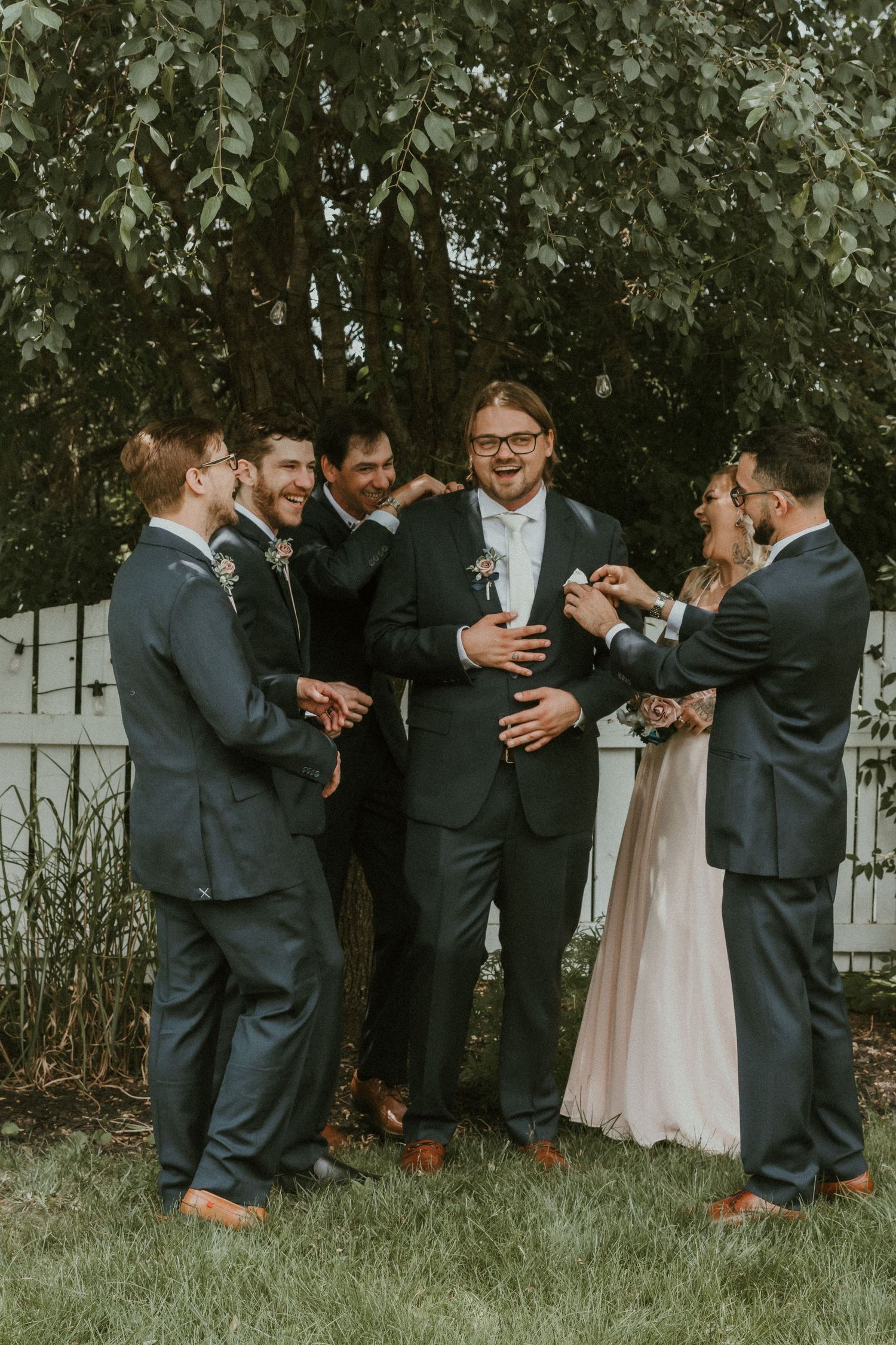 Groomsmen fixing Groom during wedding portraits with Central Illinois Wedding Photographer