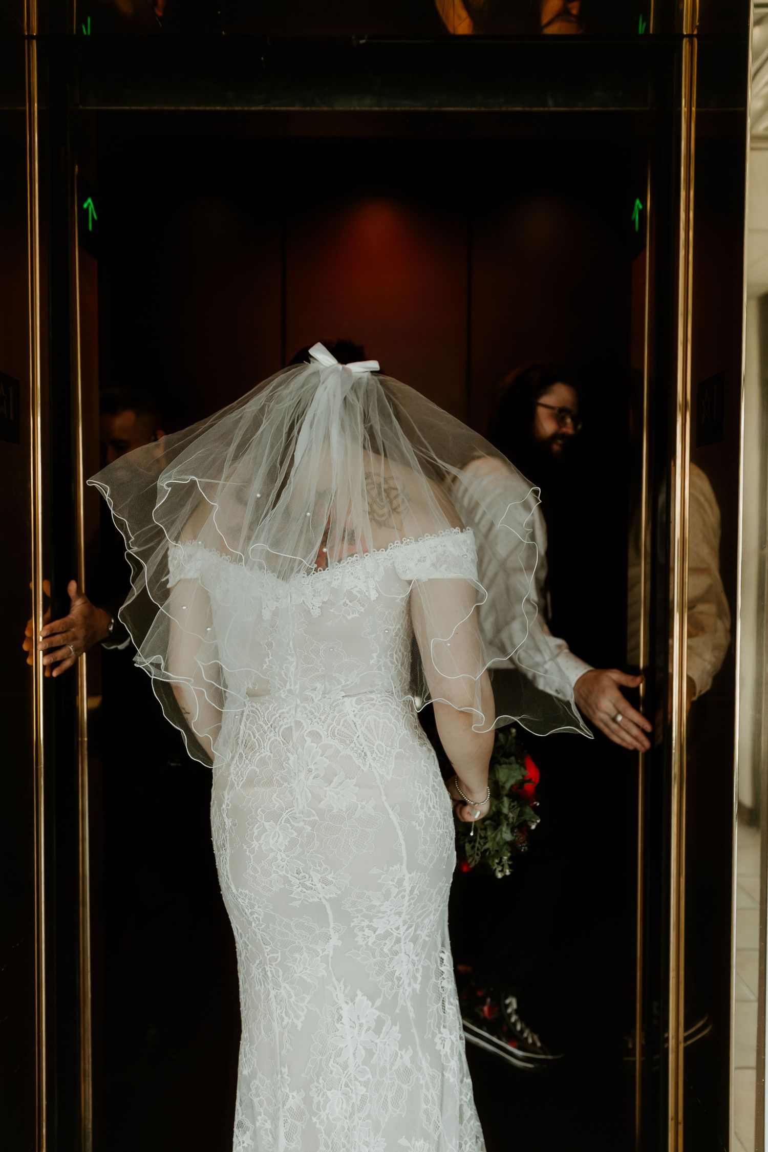 Bride enters elevator during las vegas elopement captured by destination wedding photographer at the little white chapel