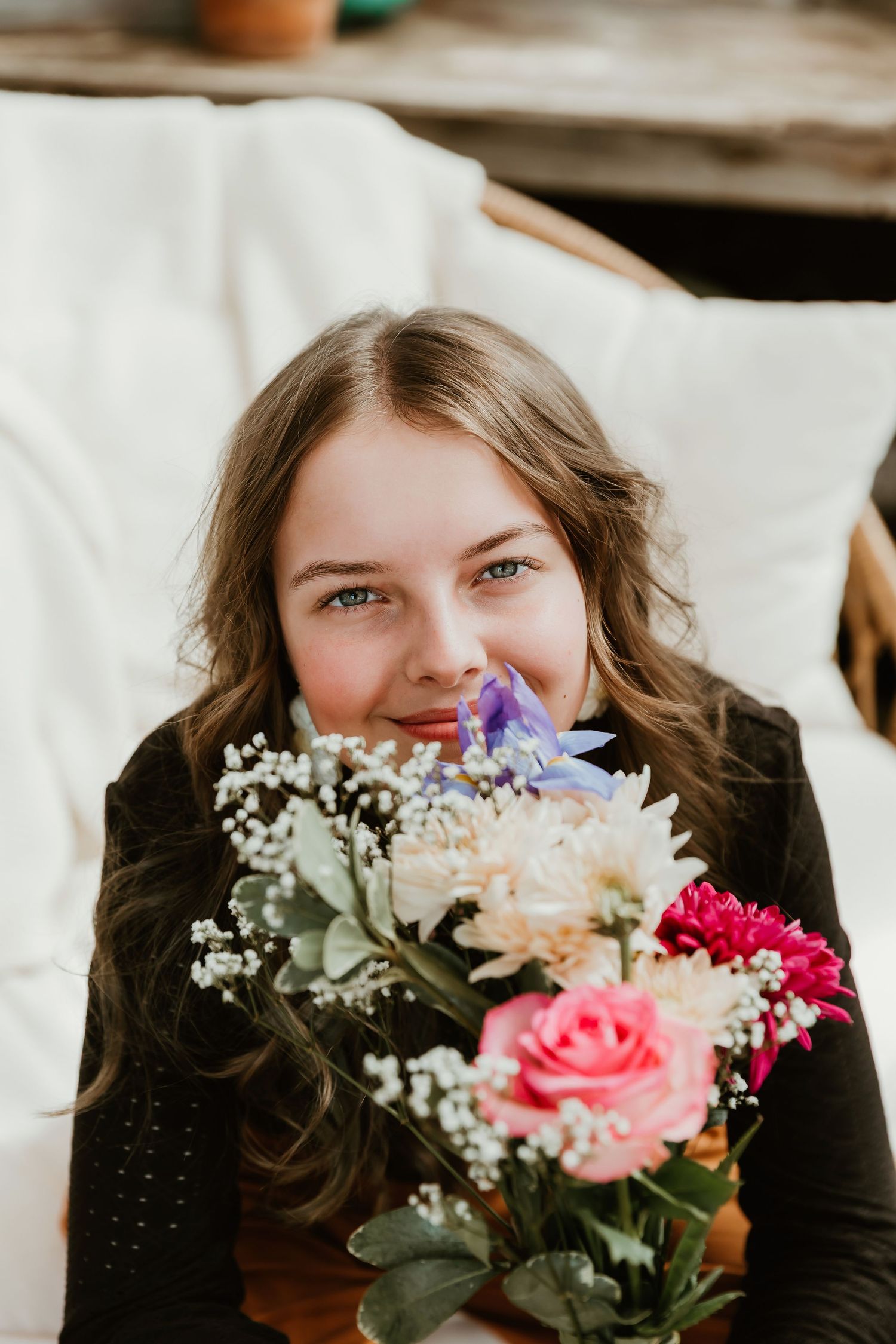 Daughter holds flowers to her eyes during a detailed photo for mom of the growth of her baby girl during a mother day photo session