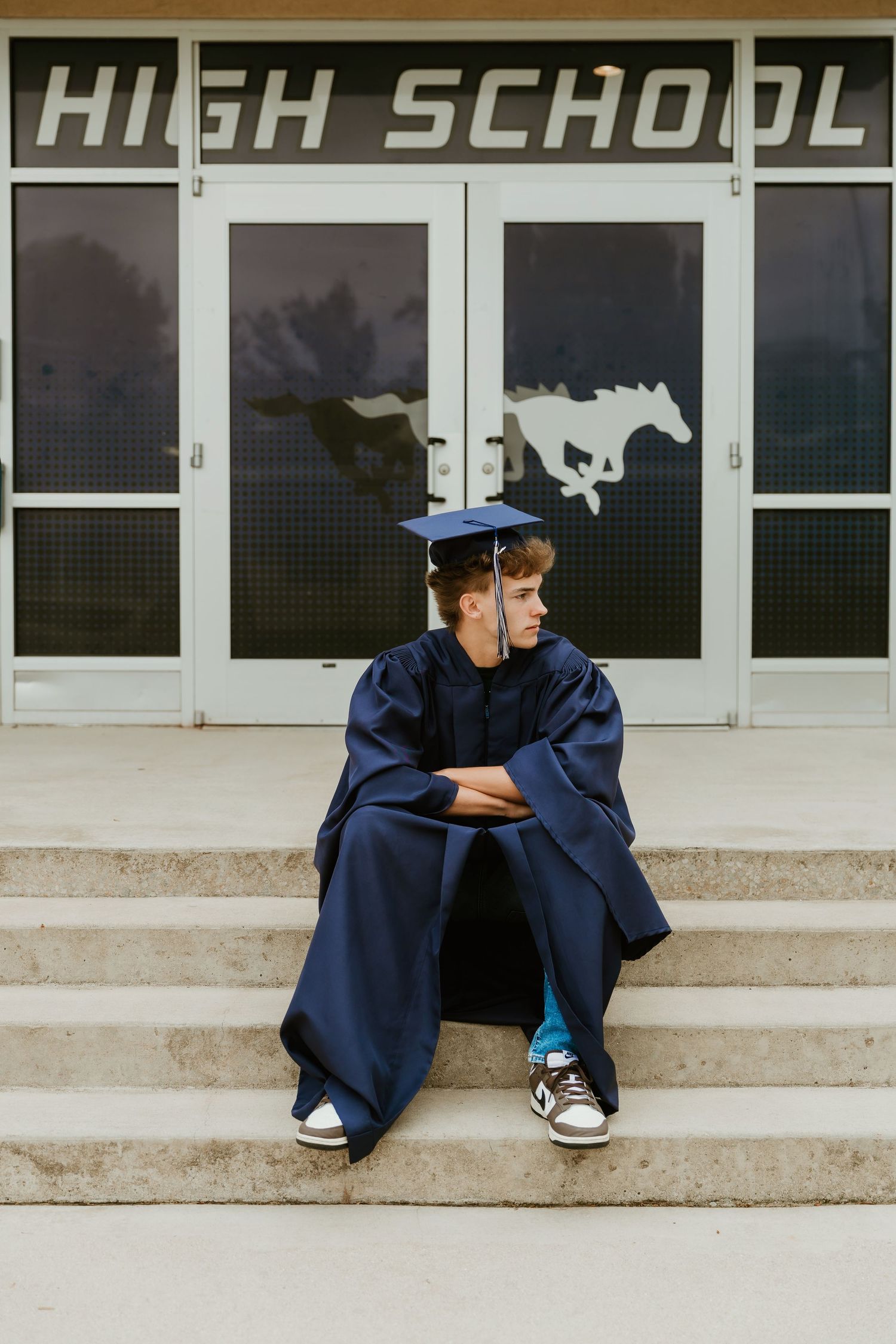 High School Senior posing on staircase at high school during a senior photoshoot with central il senior photographer