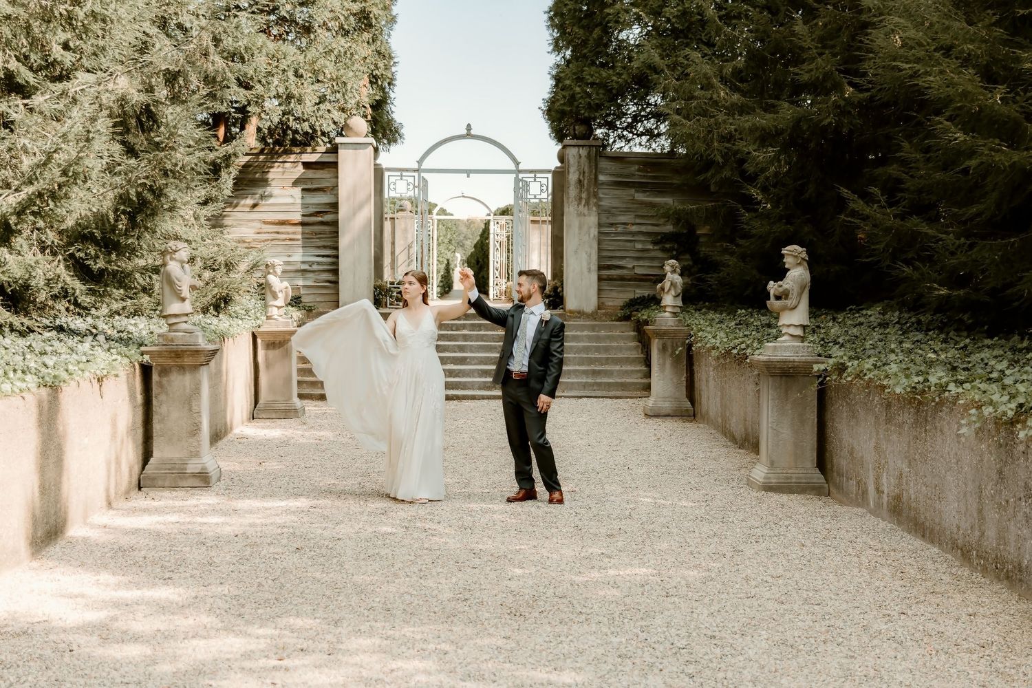 Bride floofs her dress with her groom during a dramatic wedding portrait at allerton park with central illinois photographer