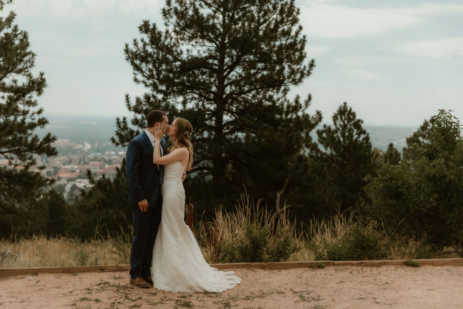Bride & Groom share an intimate moment in an open field surrounded by mountains during wedding portraits with colorado wedding photographer
