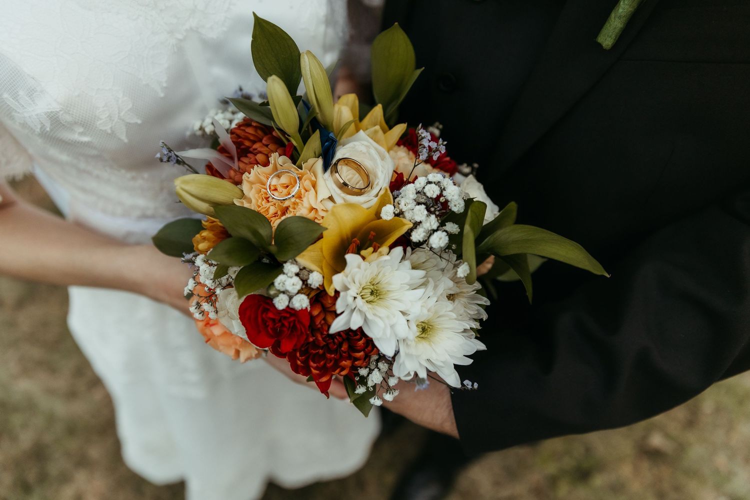 Bride's bouquet with wedding bands nestled among the flowers, capturing a beautiful and symbolic wedding detail