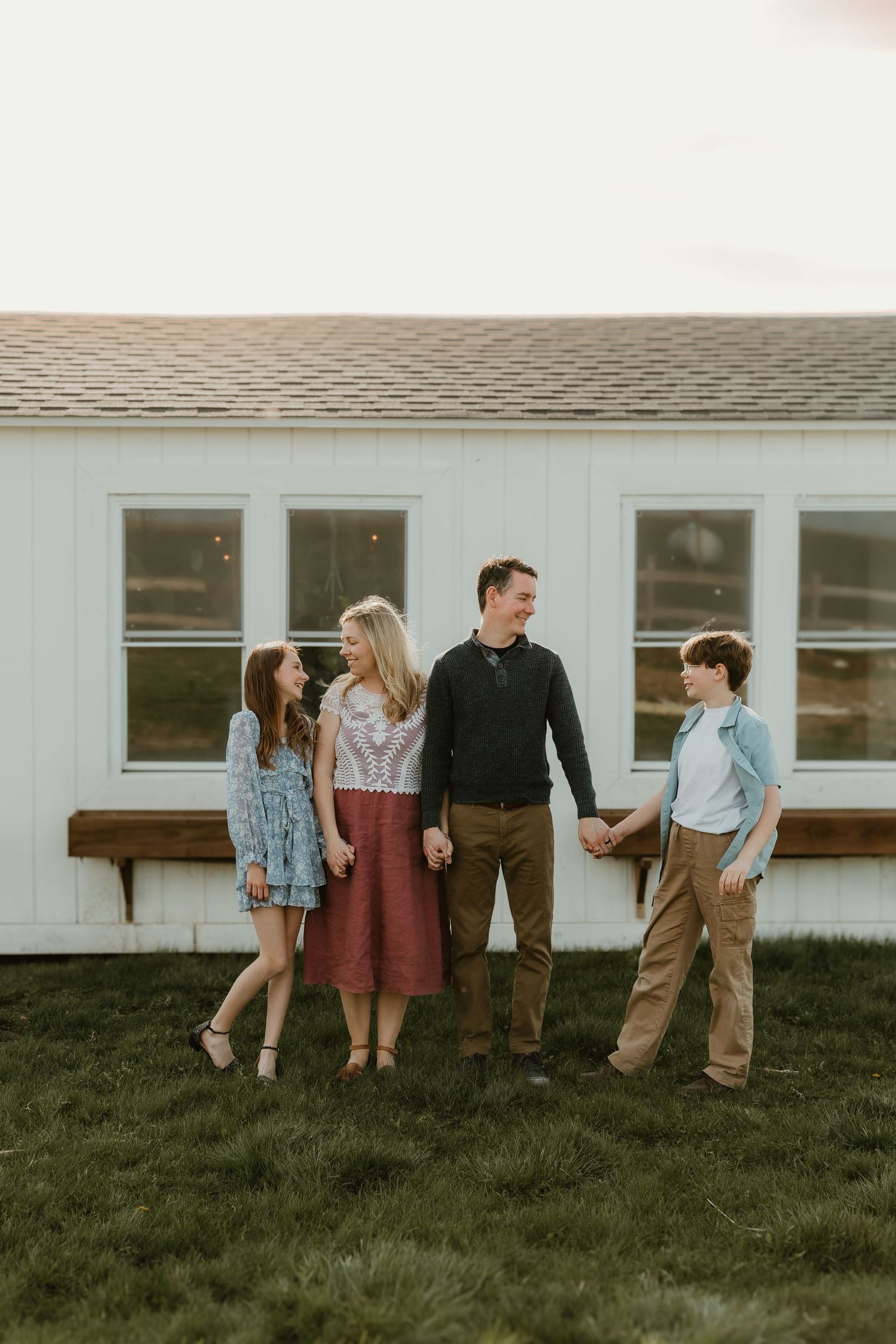 Family takes a stroll by a greenhouse during a playful moment with central illinois photographer