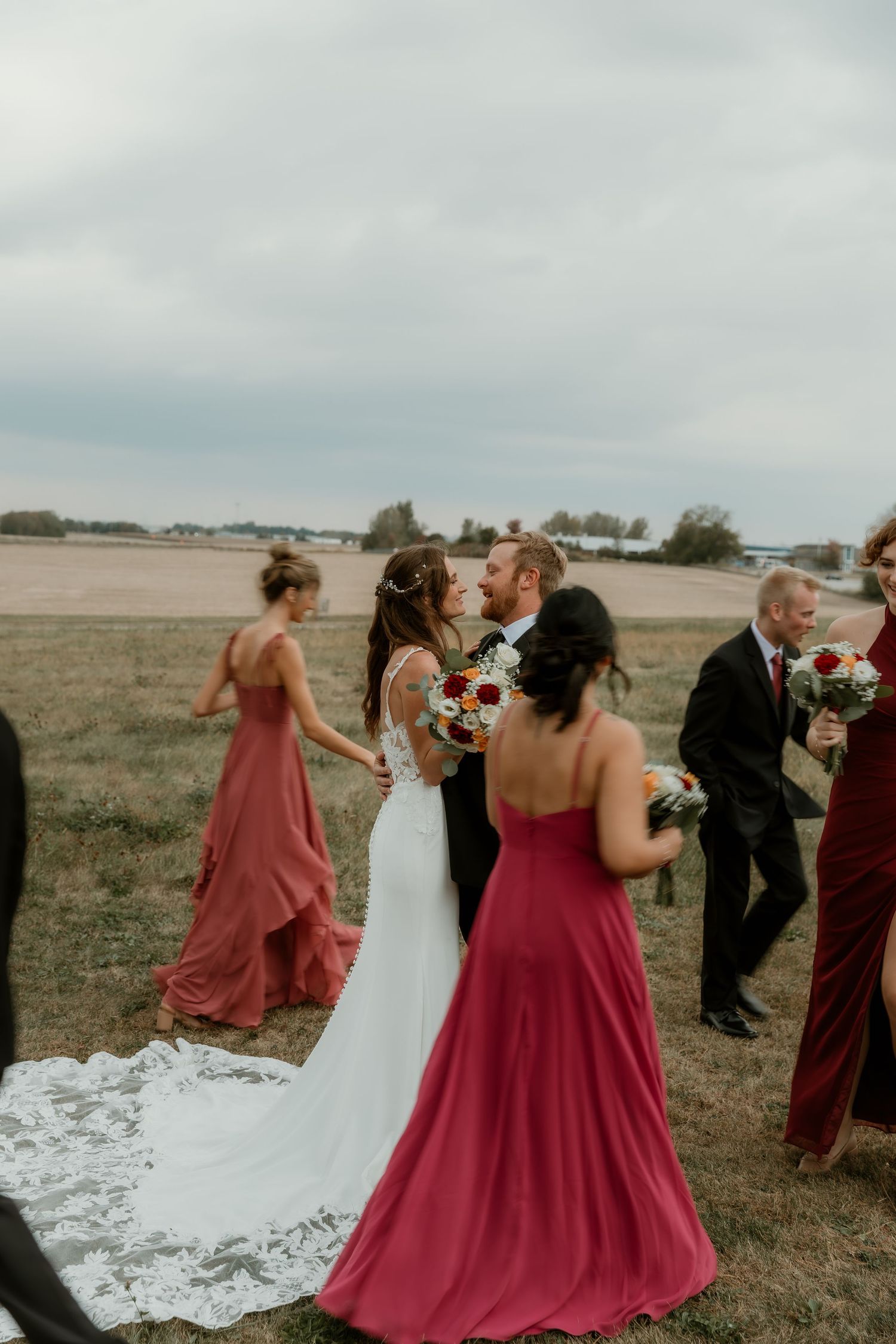 Bride and Groom stand in the middle as their wedding party walks around them during wedding party portraits