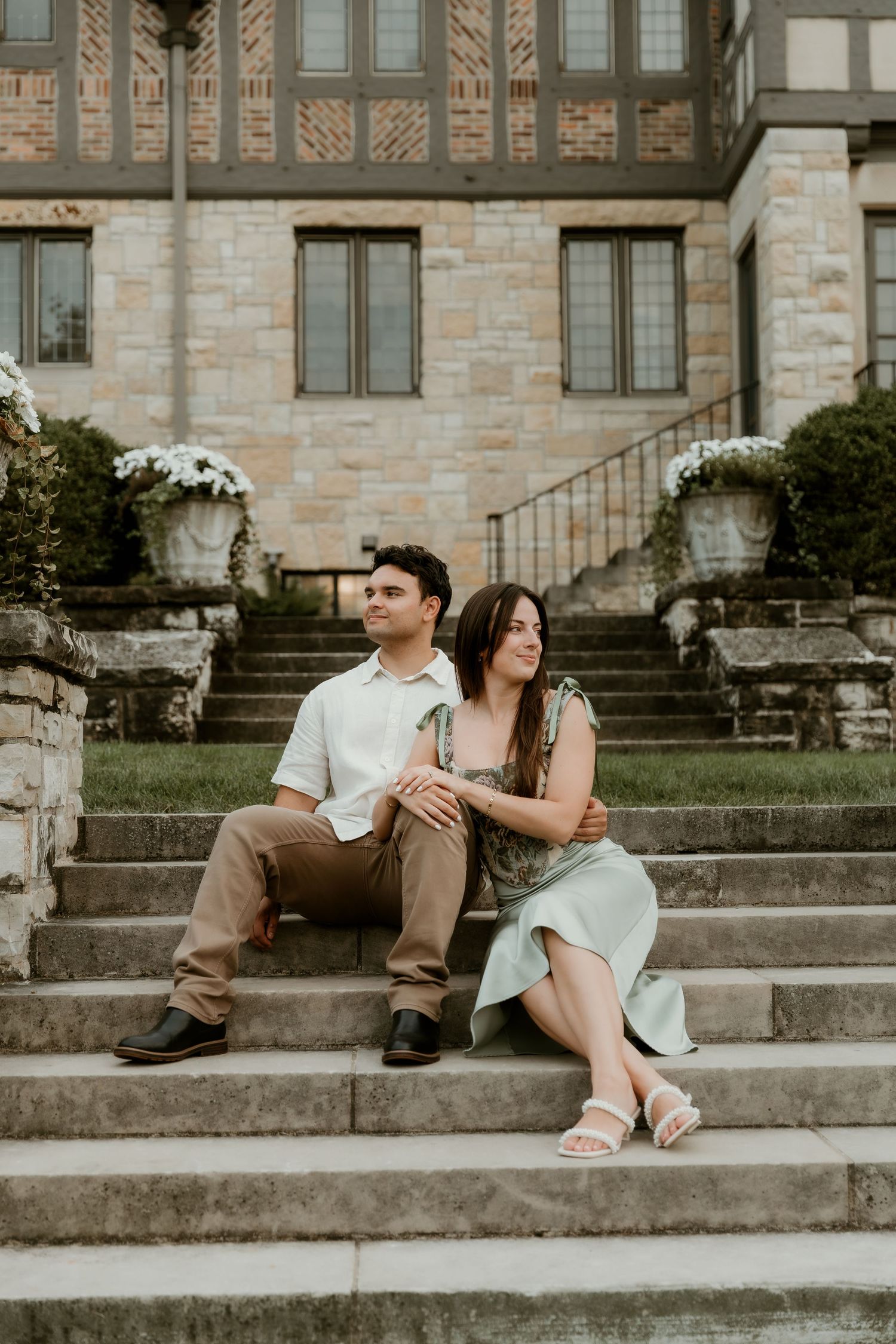 Couple sits on ewing manor staircase cuddling into each other for a romantic moment during their engagement session