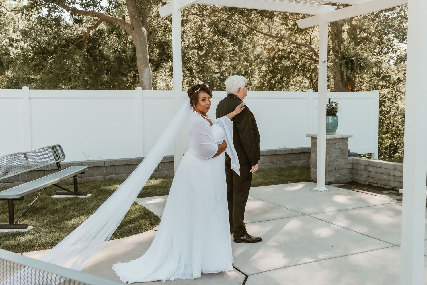 Bride gently touches groom's shoulder during their first look, capturing a moment of anticipation and love