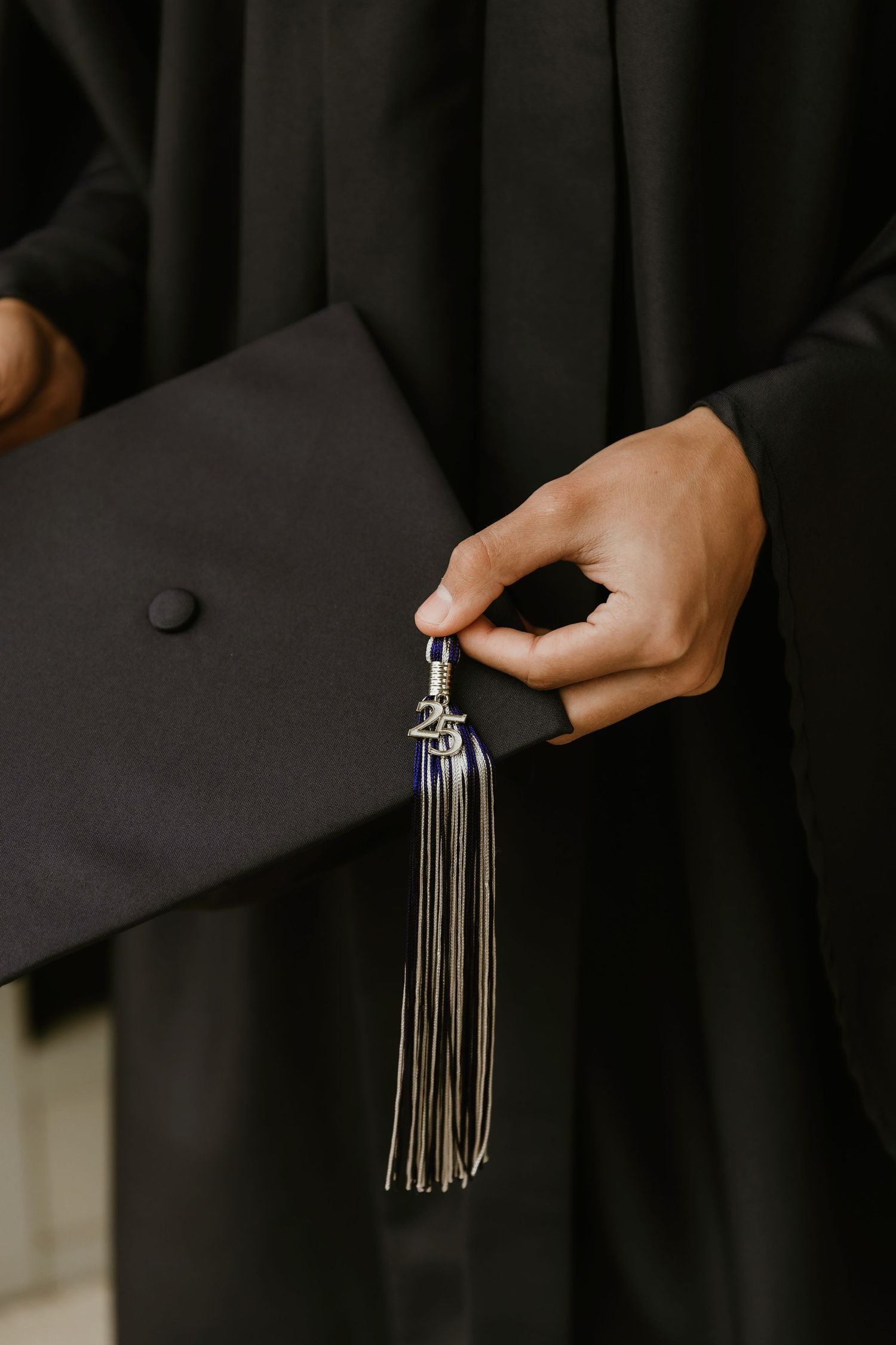High school senior shows off their cap and tassle for a detailed photo during senior photo session
