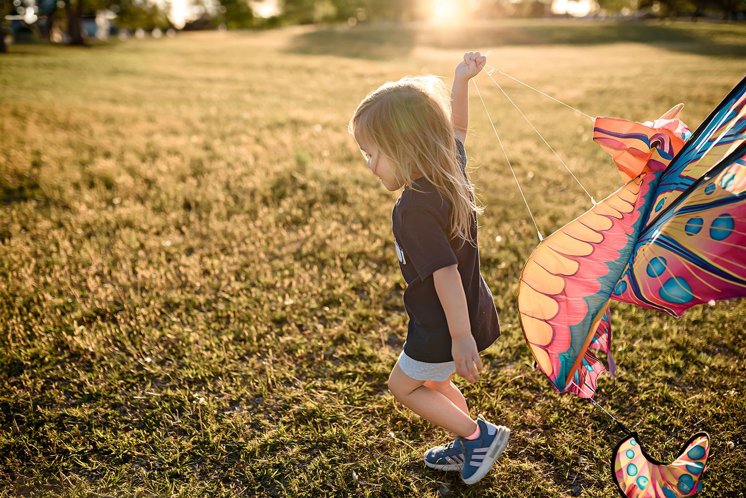 A little girl attempts to fly a kite during a fun family photo session in Scottsdale.