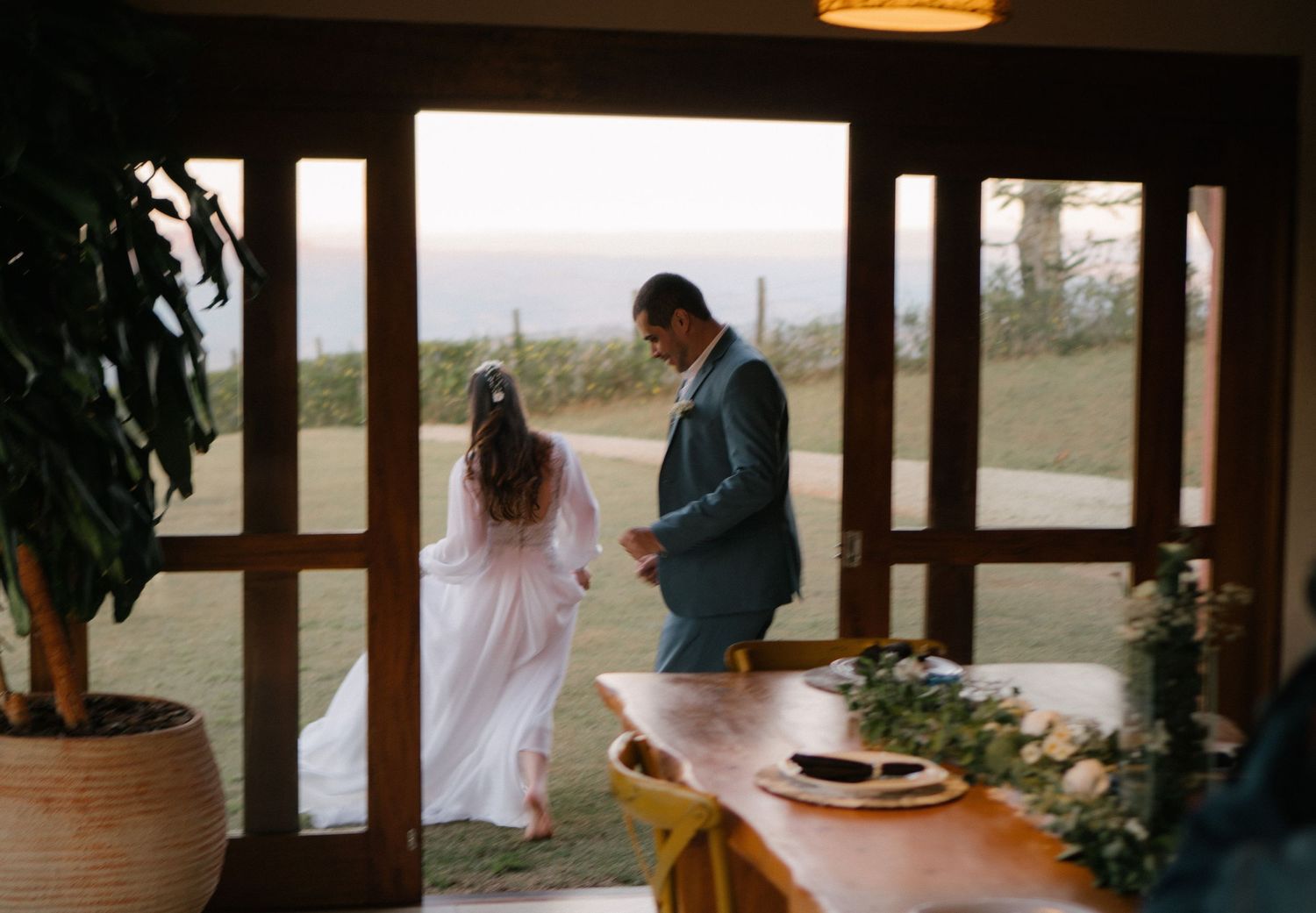 Casal corre por um local fechado durante sua celebração de casamento.