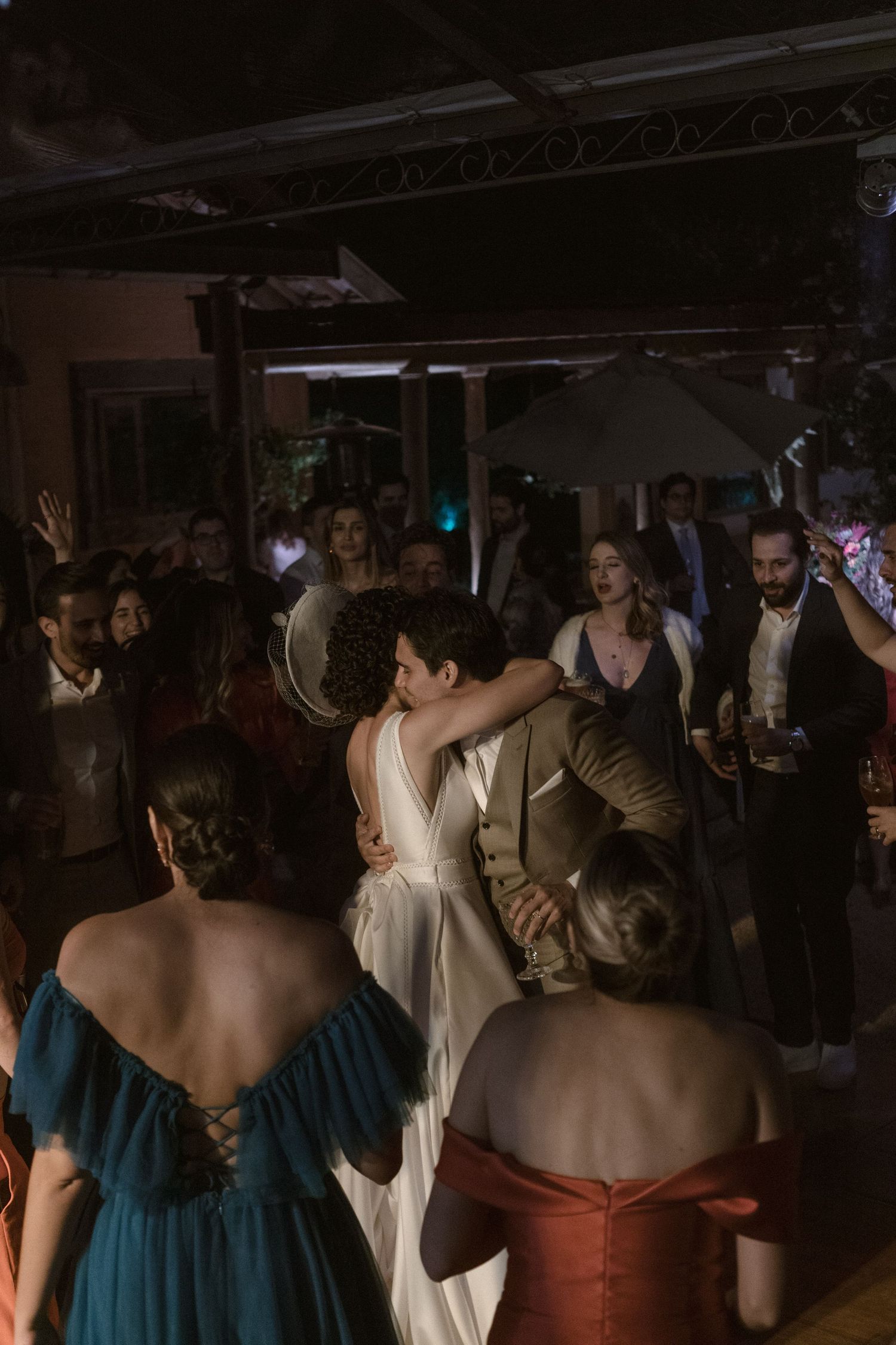 Celebração de casamento em pista de dança com iluminação suave, onde os convidados dançam e aproveitam a festa