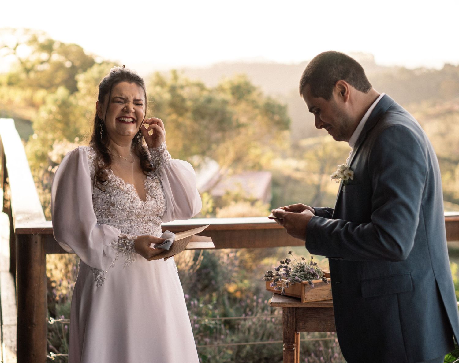 Couple reading vows from phones during outdoor mountaintop wedding ceremony.