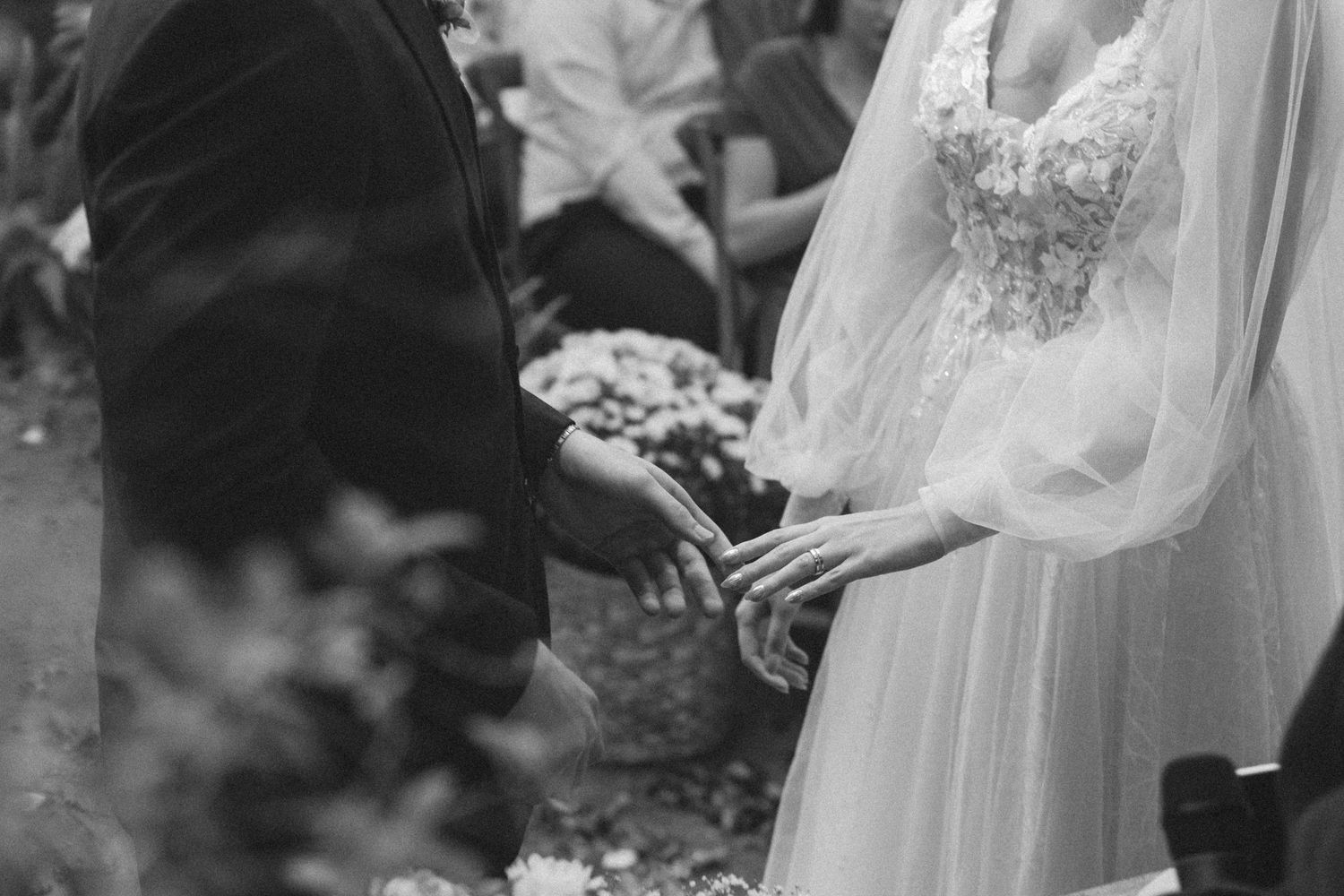 Vintage-style black and white photo of wedding ring exchange ceremony.
