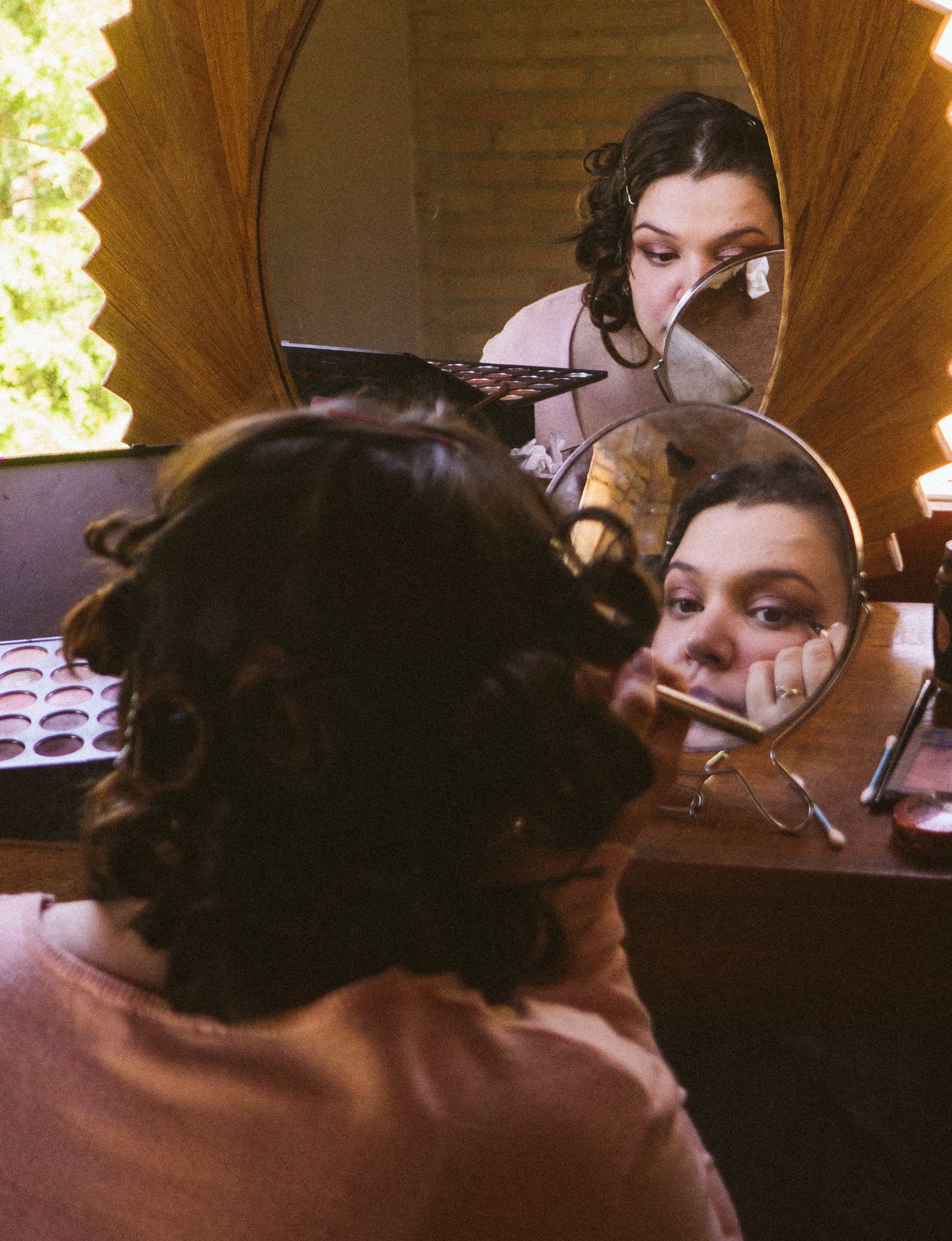 Getting ready scene with vintage-style mirrors reflecting wedding day preparations.