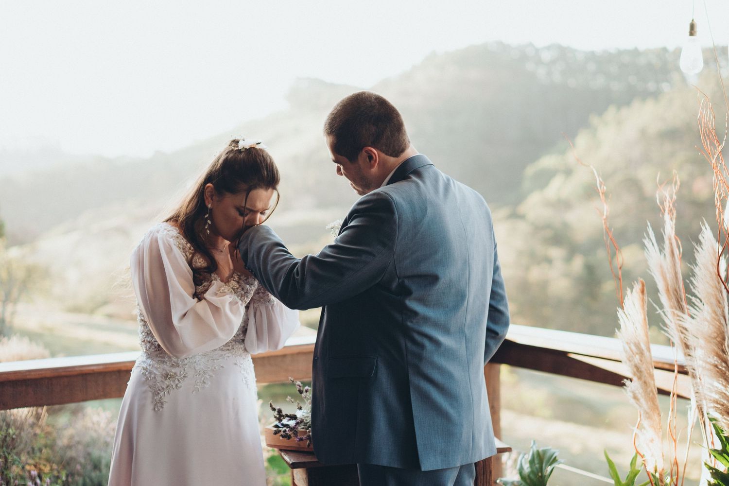 Momento emocionante da cerimônia de casamento em um mirante panorâmico nas montanhas com decoração em tecido branco.