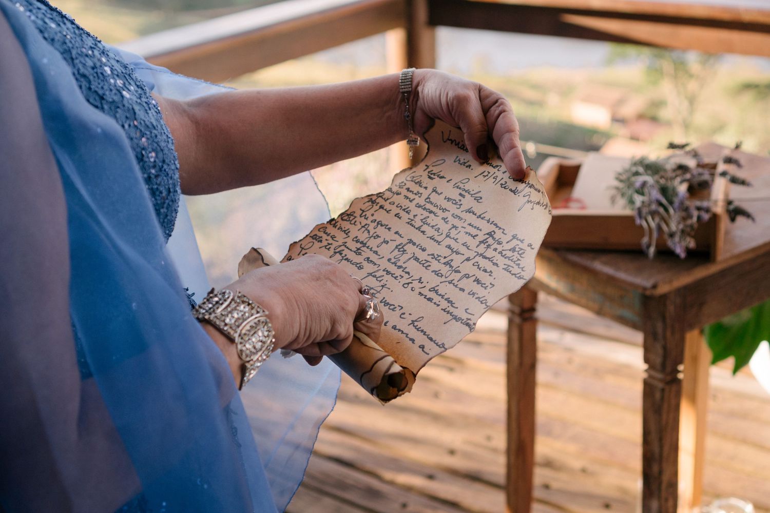 A close-up of weathered handwritten paper being held during an outdoor ceremony.