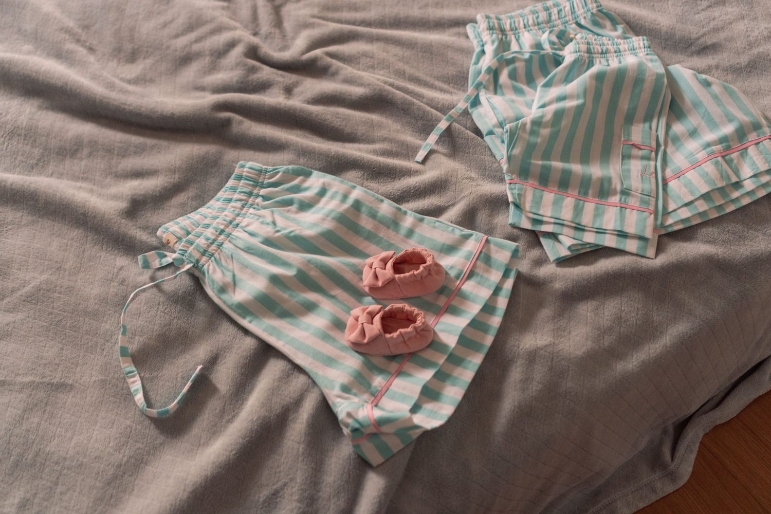 Roupas de bebê na cama © Clara e Matheus Fotógrafos de Casamentos