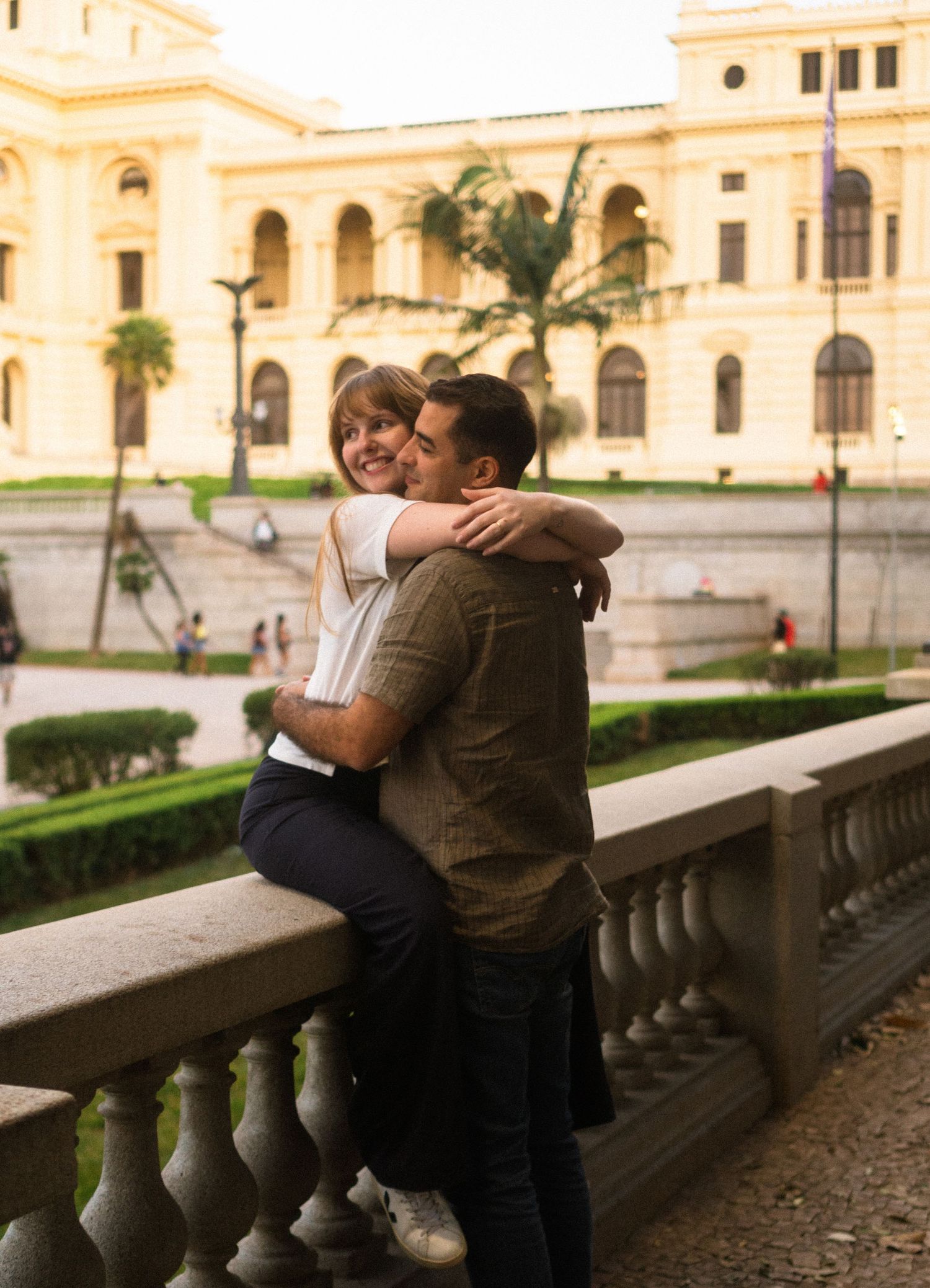 Casal abraçado em praça memorial de São Paulo © Clara e Matheus Fotógrafos de Casamentos