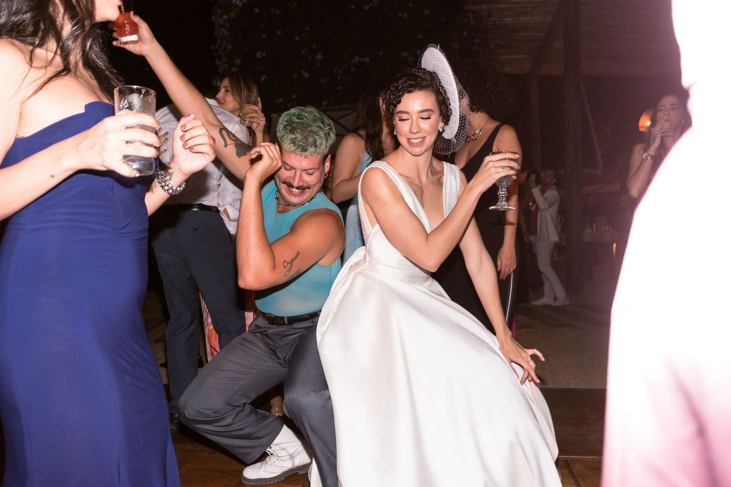 Convidados e noiva dançam com energia na pista de dança durante a celebração da recepção de casamento