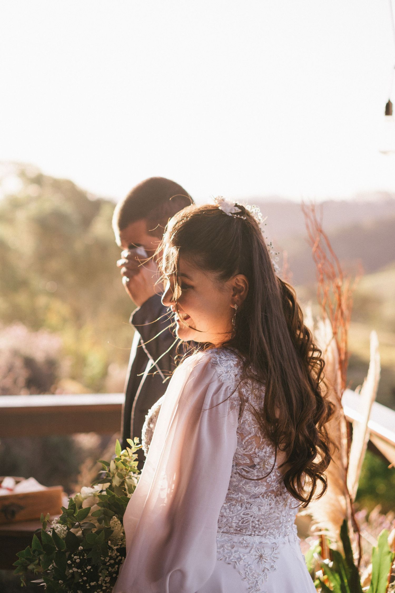 A backlit wedding portrait during golden hour on an outdoor deck.