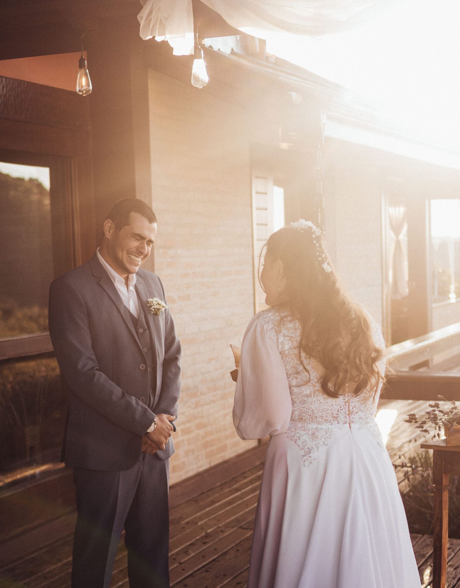 A tender moment between newlyweds during their ceremony on a sun-drenched deck with mountain views.