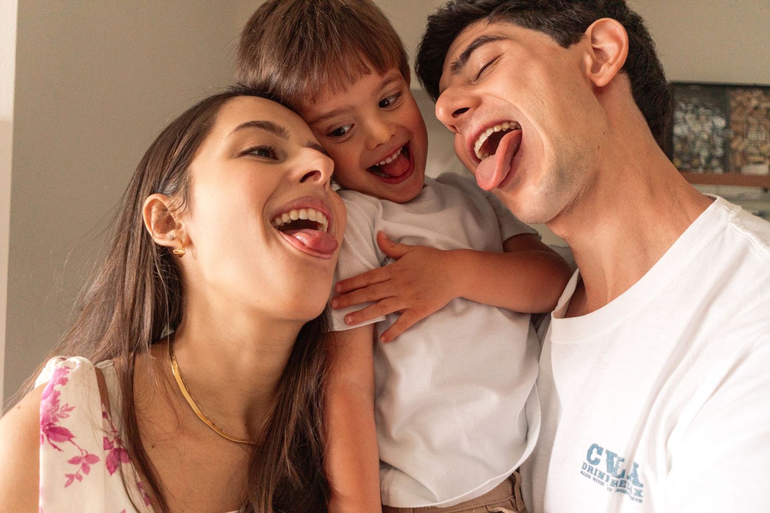 Pai, mãe e filho fazem careta um pro outro, se divertindo © Clara e Matheus Fotógrafos de Casamentos